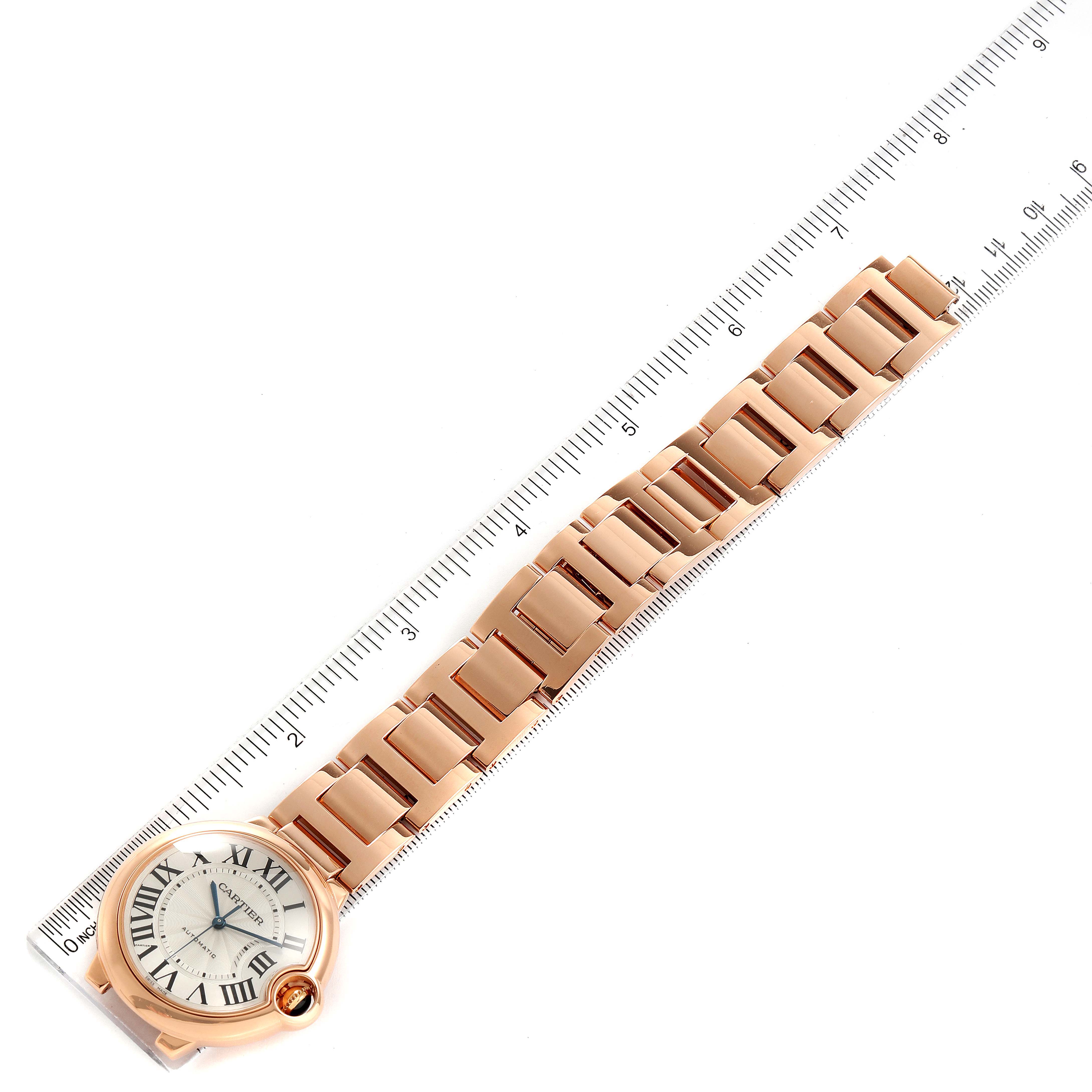The image shows a Cartier Ballon Bleu W69004Z2 Men's Rose Gold Silver Dial W69004Z2 Men's Rose Gold Silver Dial watch laid flat with its bracelet extended next to a ruler.