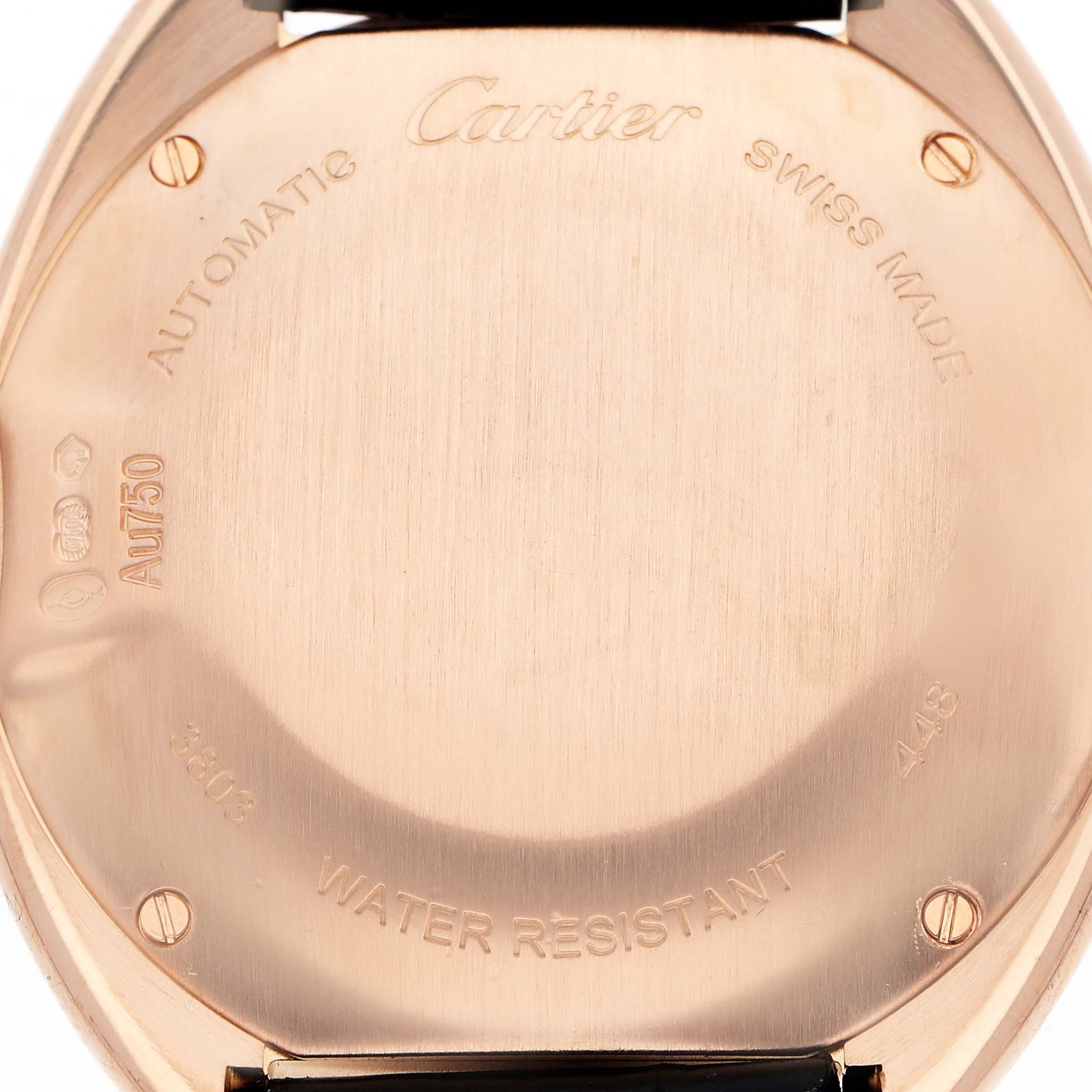 The image shows the back case of a Cartier Clé watch, highlighting engravings and screws.