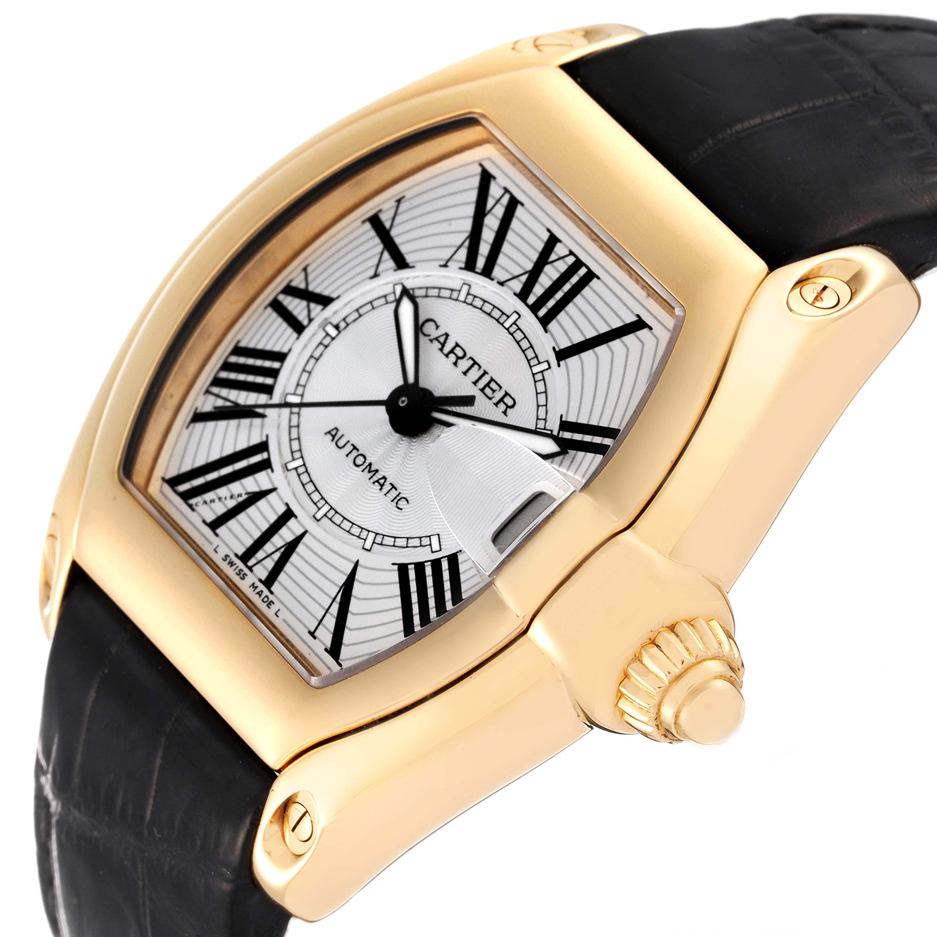 The image shows a Cartier Roadster W62005V2 Men's Yellow Gold Silver Dial W62005V2 Men's Yellow Gold Silver Dial watch at an angled close-up, highlighting the dial, crown, and part of the black strap.