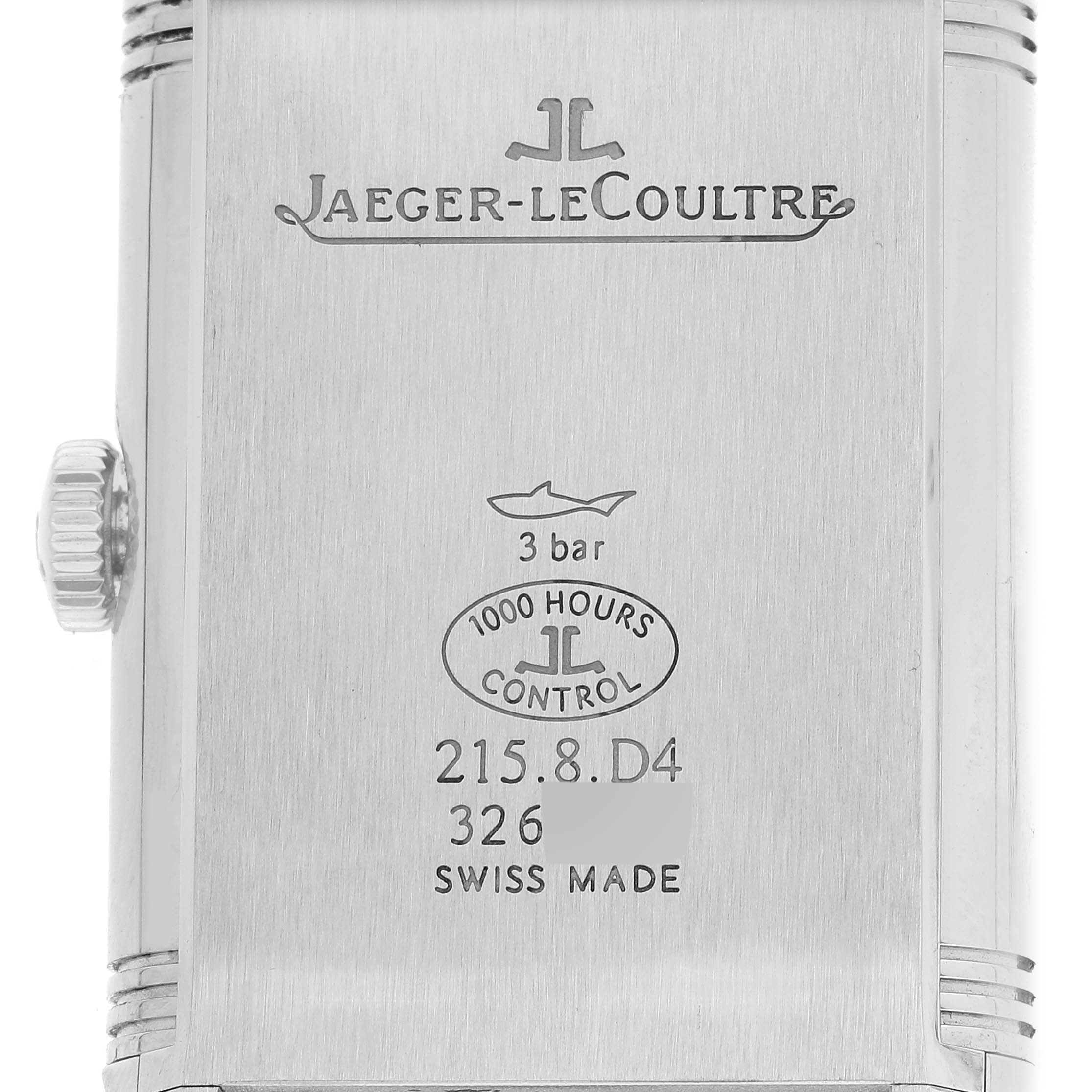This image shows the back case of a Jaeger-LeCoultre Reverso watch, featuring its engravings and crown from a straight angle.