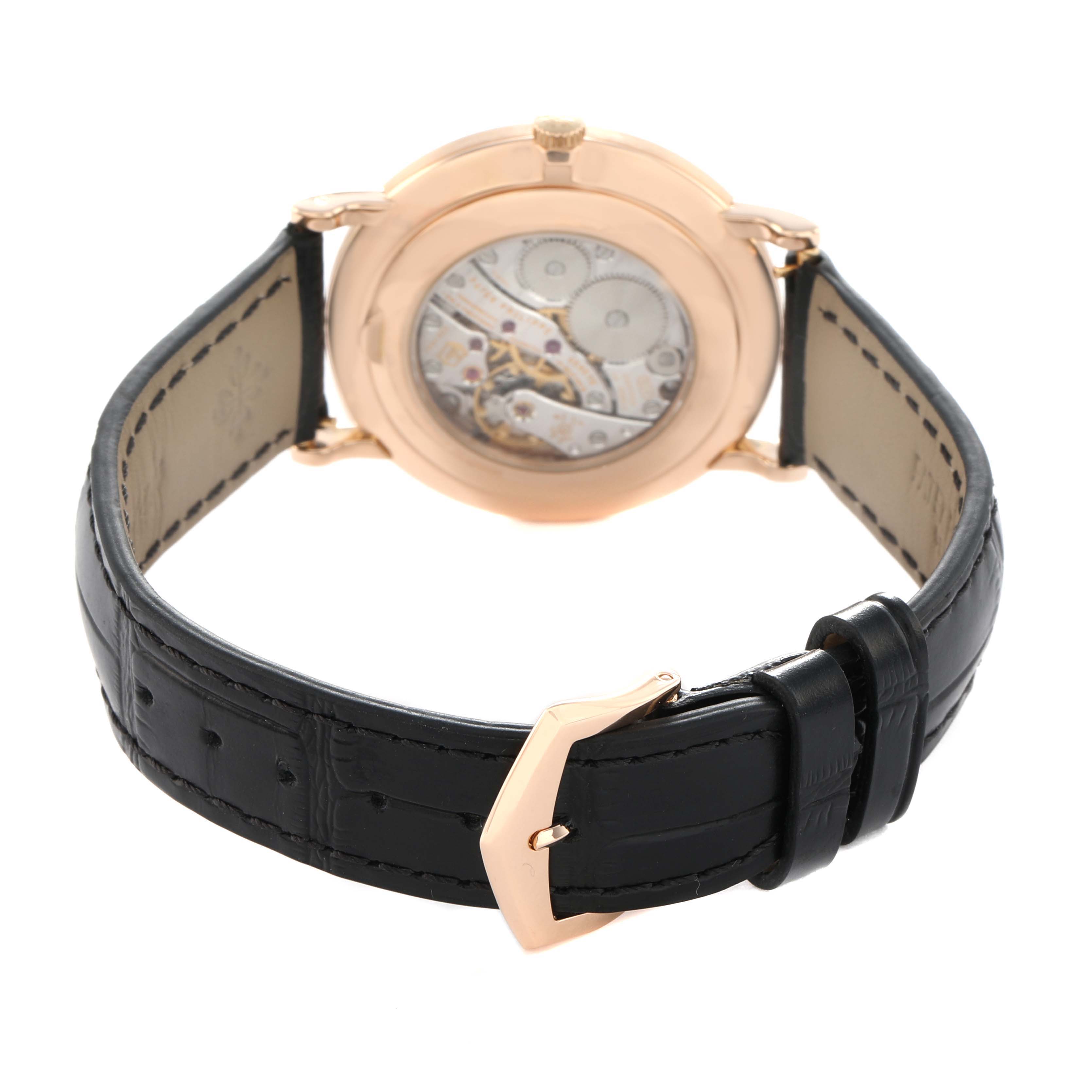 The image shows the back view of a Patek Philippe Calatrava 5116R Men's Rose Gold White Dial, displaying the movement and black leather strap with a buckle.