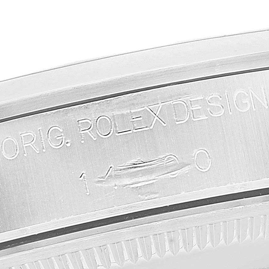 The image shows a close-up of the edge of a Rolex Air-King 14000 Men's Stainless Steel White Dial 14000 Men's Stainless Steel White Dial watch case with engraved text indicating "ORIG. ROLEX DESIGN".