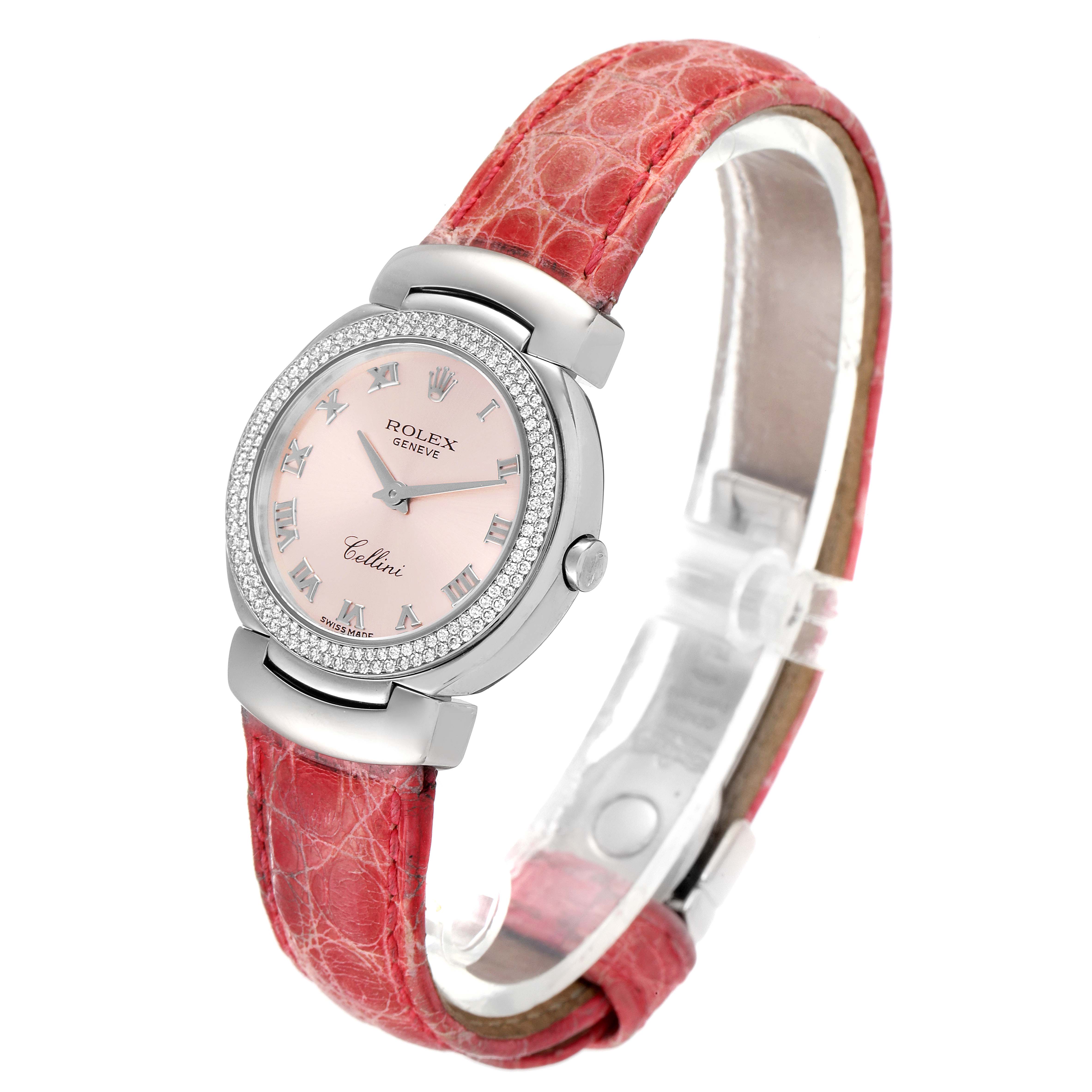 The Rolex Cellini 6671 Women's White Gold Pink Dial 6671 Women's White Gold Pink Dial watch is angled in a three-quarter view, showcasing the dial, bezel, crown, and red leather strap.