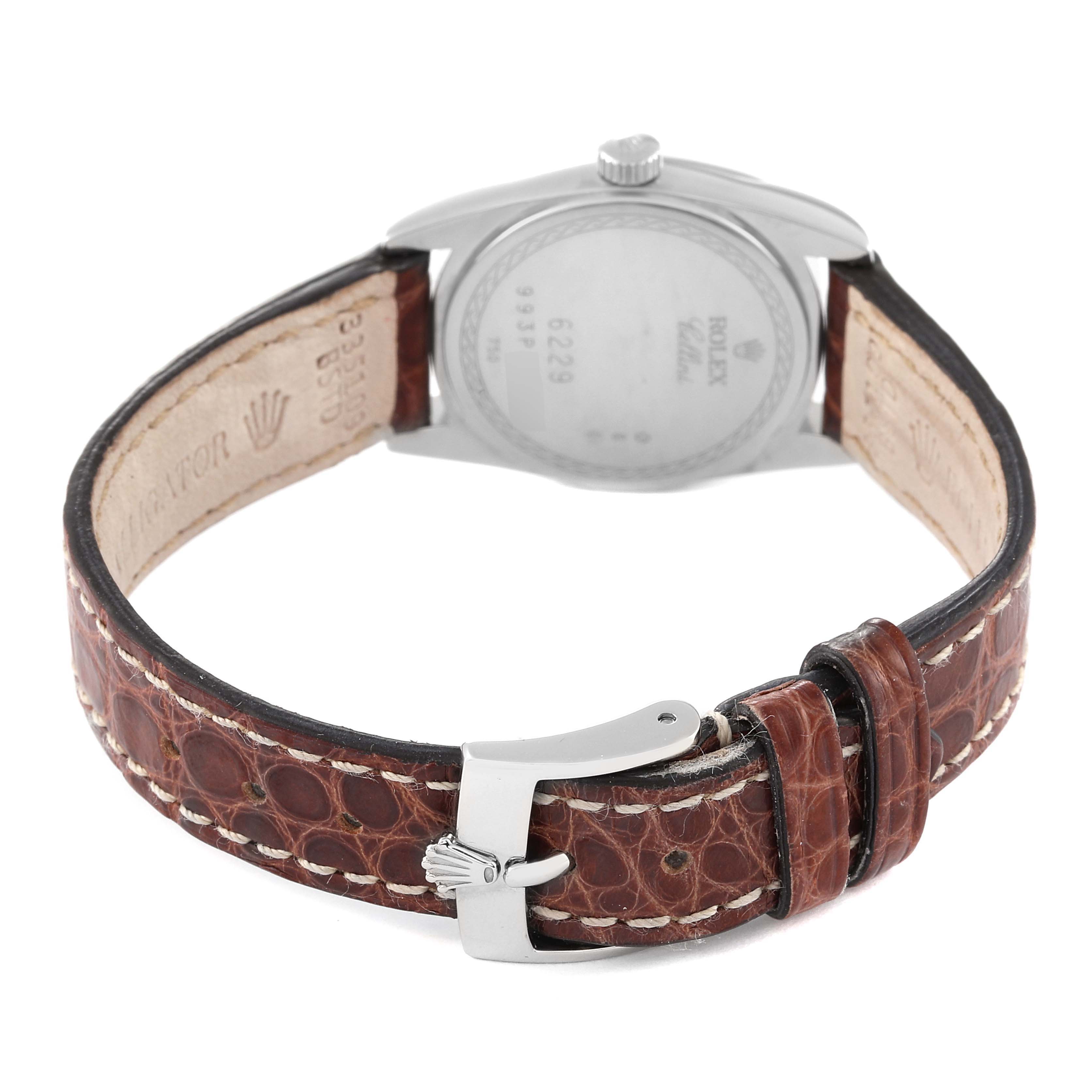 The image shows the back of a Rolex Cellini 6229 Women
s Steel and Gold (two tone) White Dial 6229 Women
s Steel and Gold (two tone) White Dial watch and its leather strap with a buckle.