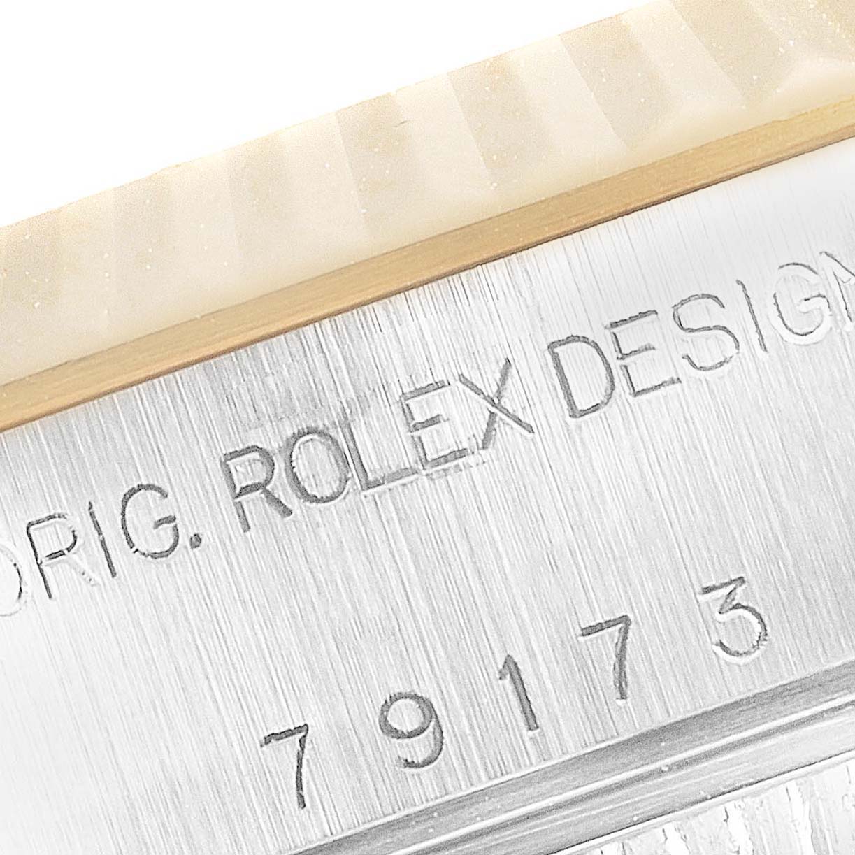 This is a close-up of the model number and "ROLEX DESIGN" engraving on the case side of a Rolex Datejust 79173 Women's Steel and Gold (two tone) White Dial 79173 Women's Steel and Gold (two tone) White Dial watch.
