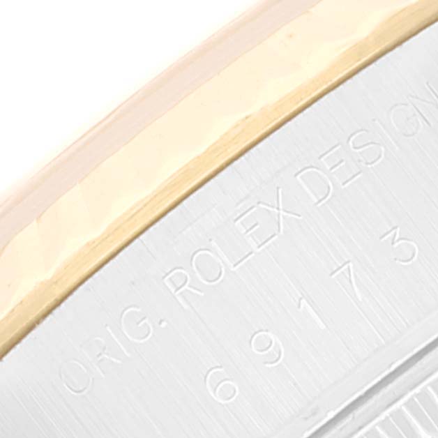 The image shows a close-up of the bezel and engraved case side of a Rolex Datejust 69173 Women's Steel and Gold (two tone) Red Dial 69173 Women's Steel and Gold (two tone) Red Dial watch.