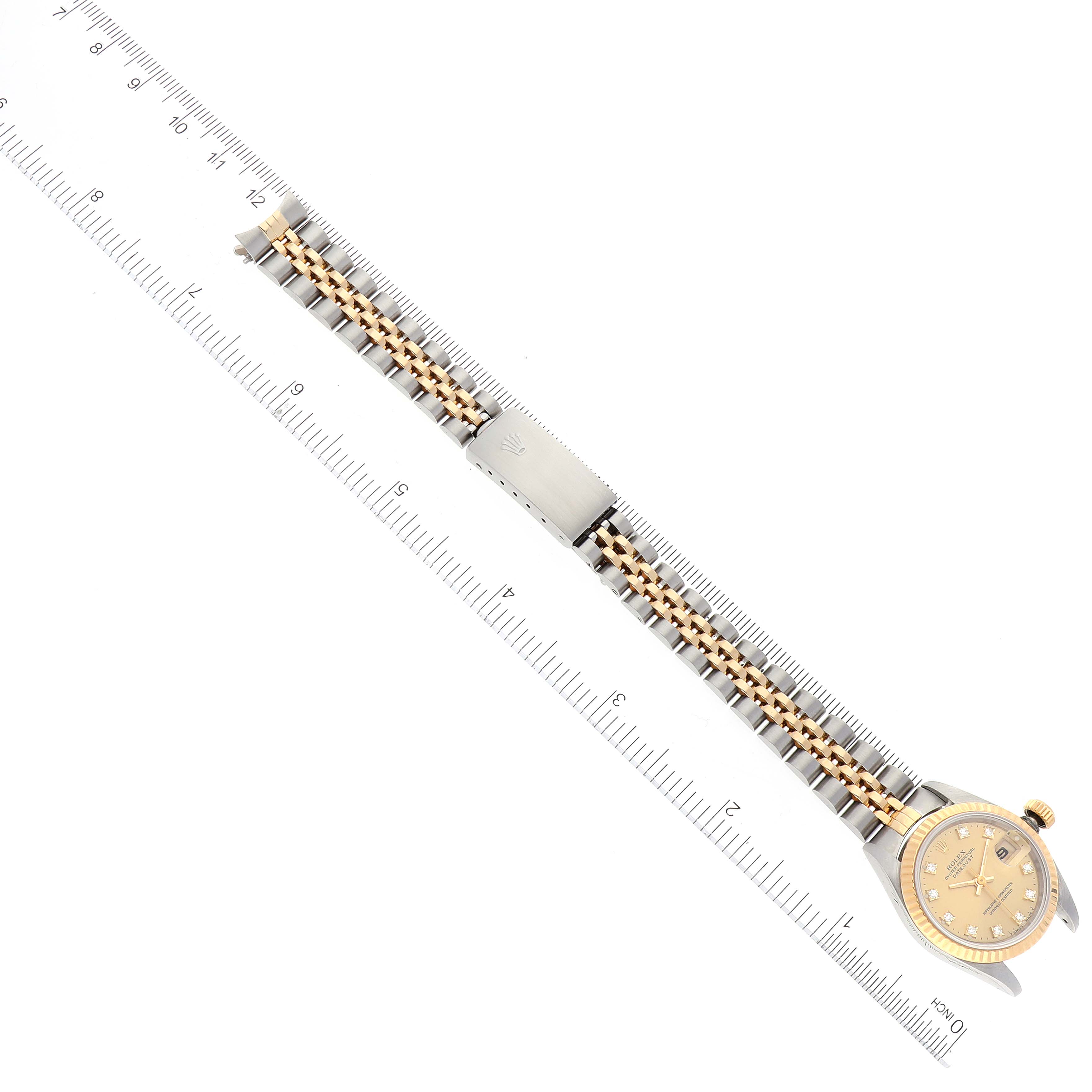 The image shows an overhead view of a Rolex Datejust 69173 Women's Steel and Gold (two tone) Champagne Dial 69173 Women's Steel and Gold (two tone) Champagne Dial watch, displaying the face, strap, and clasp against a ruler for scale.