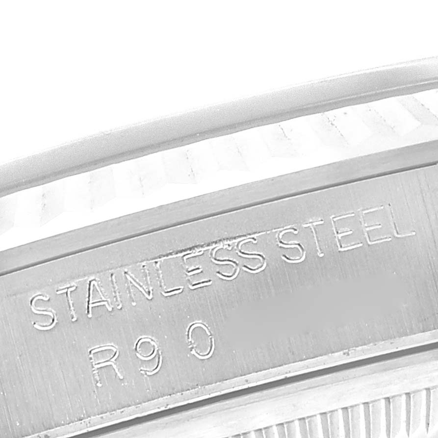 The image shows a close-up angle of the edge of a Rolex Datejust 16234 Men's Stainless Steel Blue Dial 16234 Men's Stainless Steel Blue Dial watch with "STAINLESS STEEL" engraved on it.