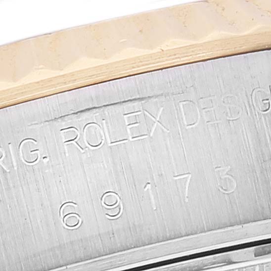 This image shows a close-up of the bezel and part of the case with engravings on a Rolex Datejust 69173 Women's Steel and Gold (two tone) Blue Dial 69173 Women's Steel and Gold (two tone) Blue Dial watch.