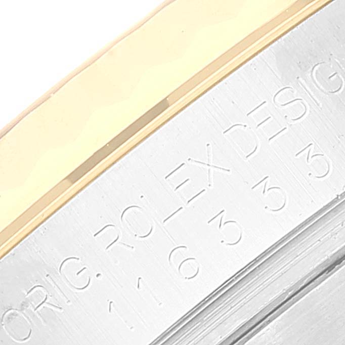 This close-up image shows the side of the bezel and part of the casing of a Rolex Datejust 41 116333 Men
s Steel and Gold (two tone) Black Dial 116333 Men
s Steel and Gold (two tone) Black Dial, highlighting engravings.