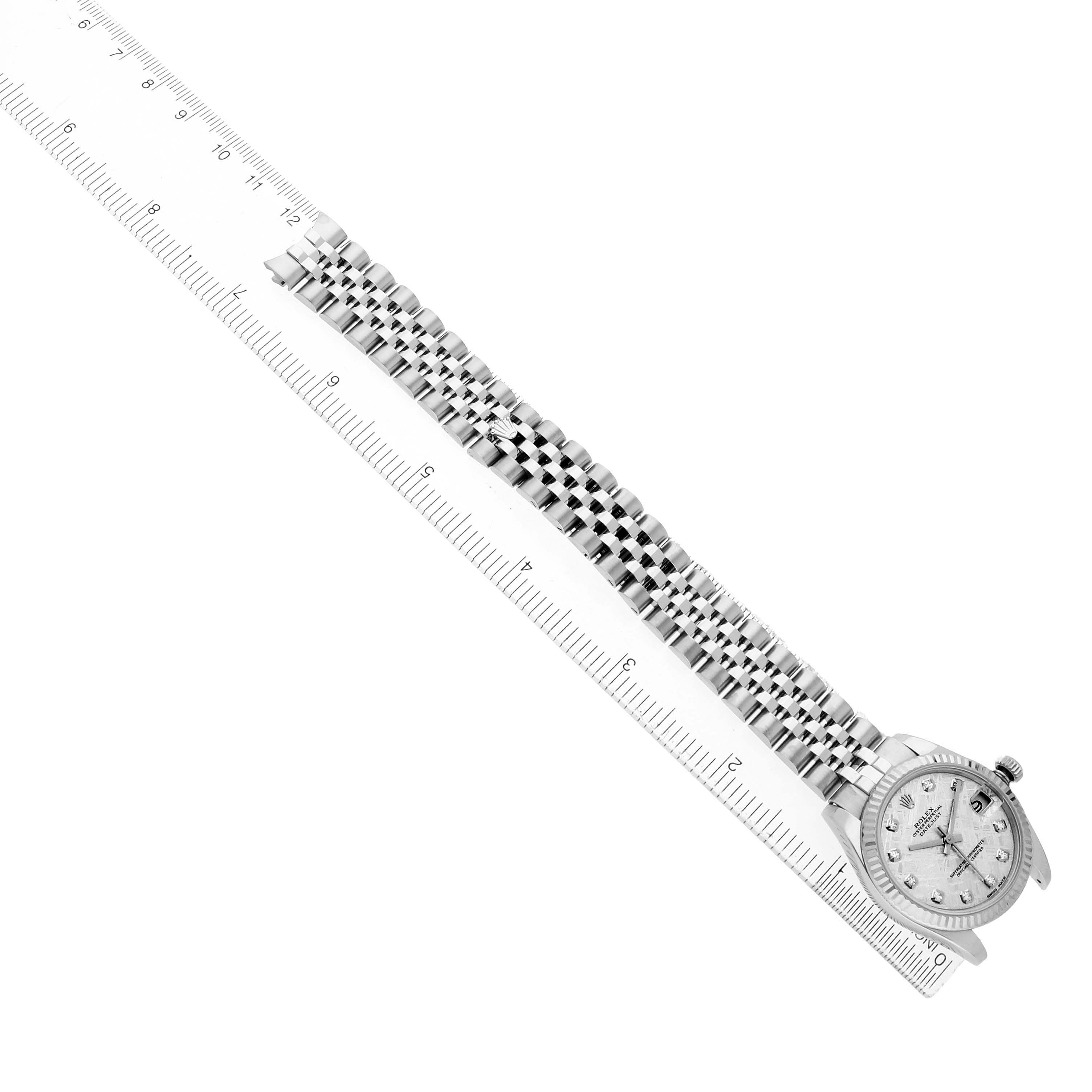 The Rolex Mid-Size 178274 Women's Stainless Steel Silver Dial watch is shown from a top view, displaying the face and full metal bracelet beside a ruler.