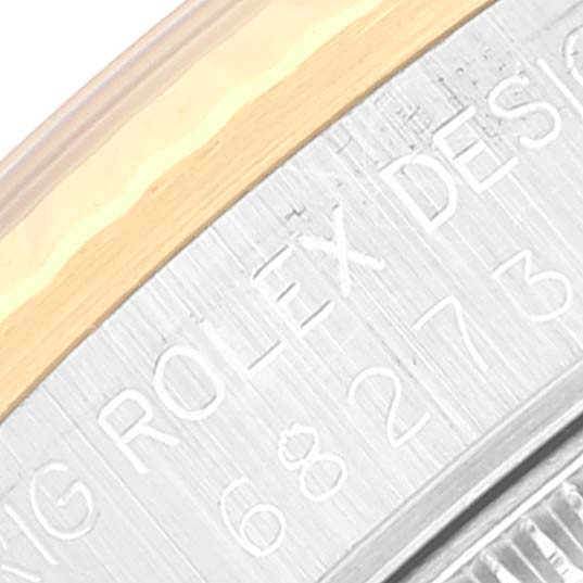 The image shows a close-up of the side of a Rolex Mid-Size 68273 Women's Steel and Gold (two tone) Champagne Dial 68273 Women's Steel and Gold (two tone) Champagne Dial model watch with visible engravings on the metal casing.