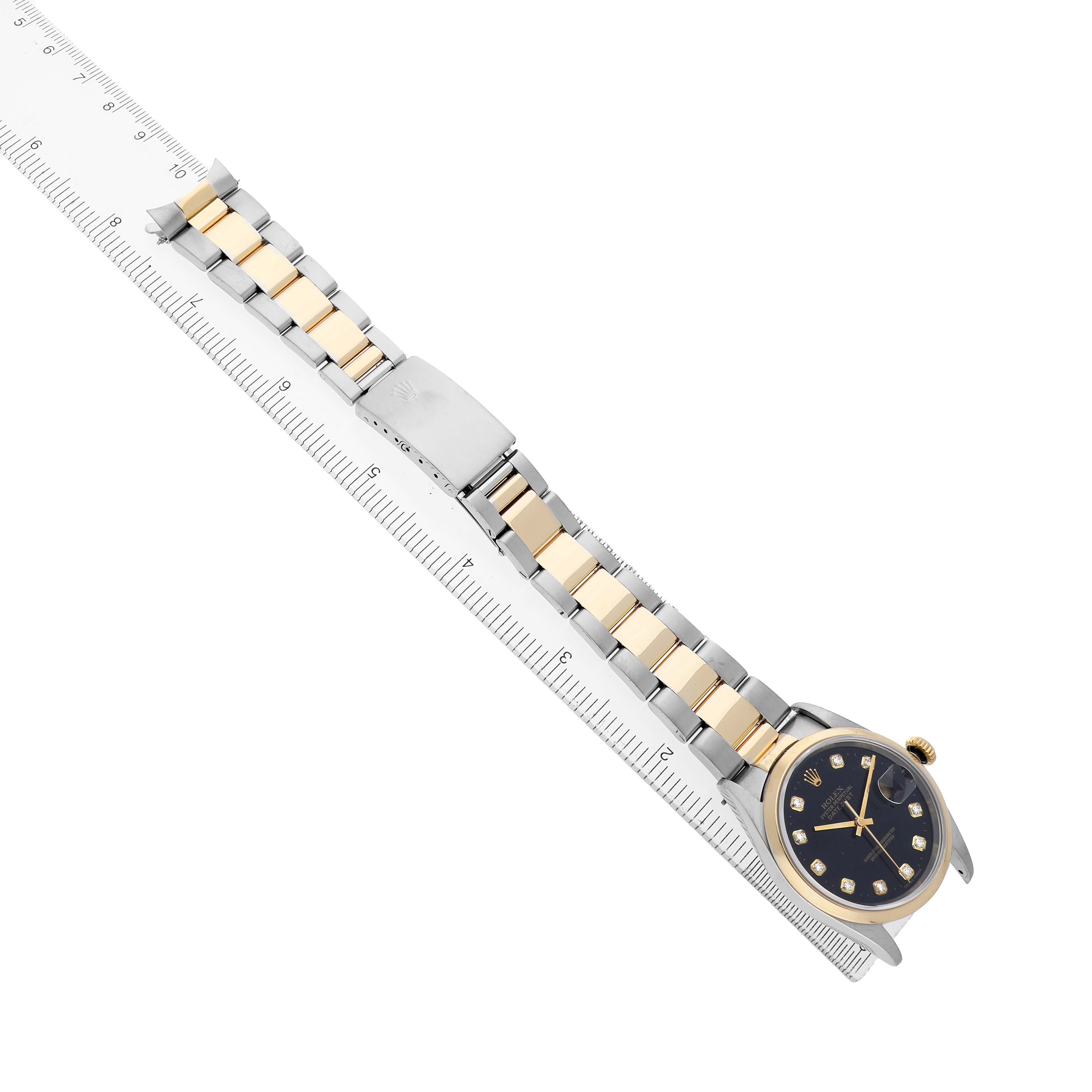 The Rolex Datejust 16203 Men's Steel and Gold (two tone) Black Dial watch is shown at an angled view, highlighting the face, dial, and two-tone bracelet alongside a ruler.