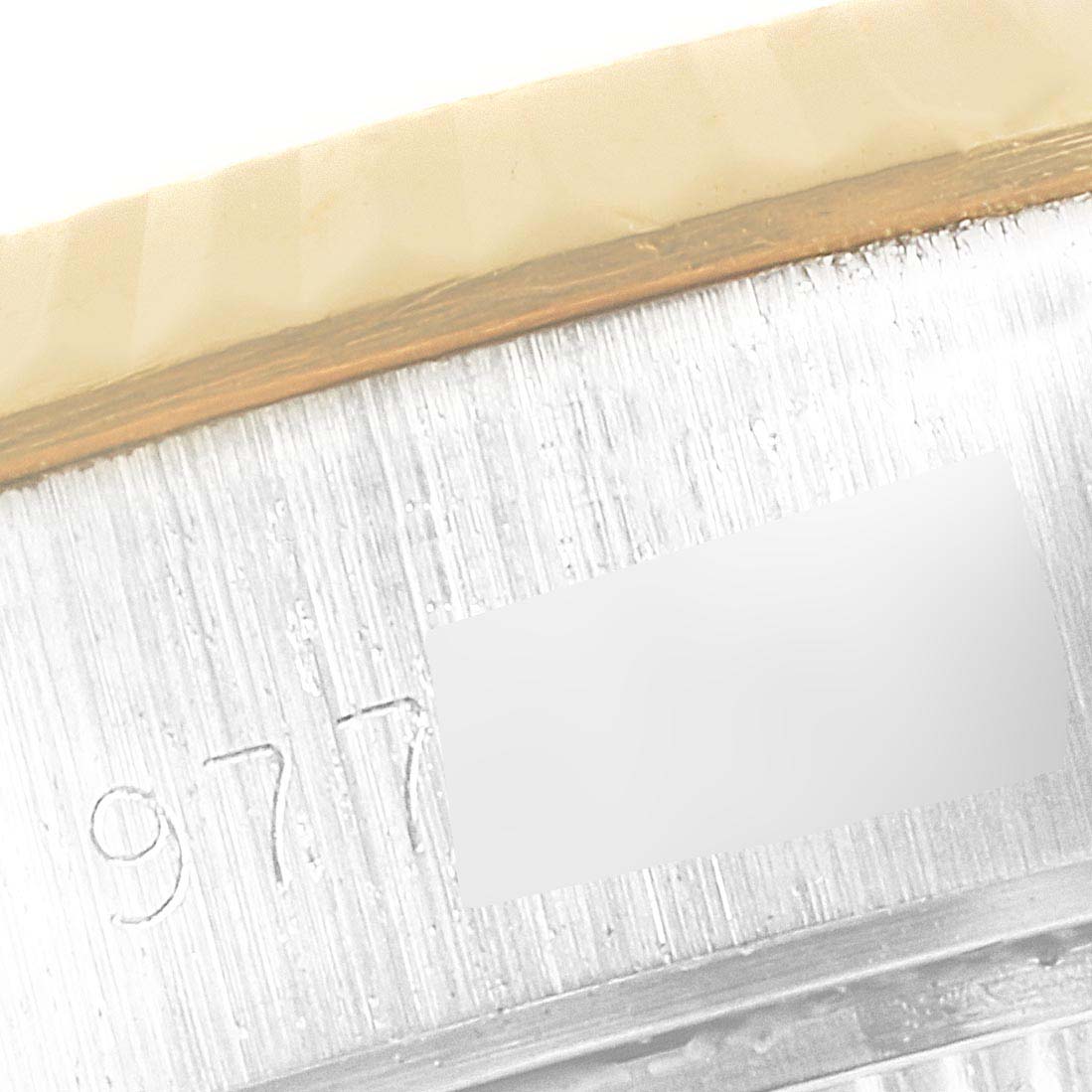 The image shows a close-up of the serial number engraving on the outer rim of a Rolex Datejust 69173 Women's Steel and Gold (two tone) Champagne Dial 69173 Women's Steel and Gold (two tone) Champagne Dial watch bezel.