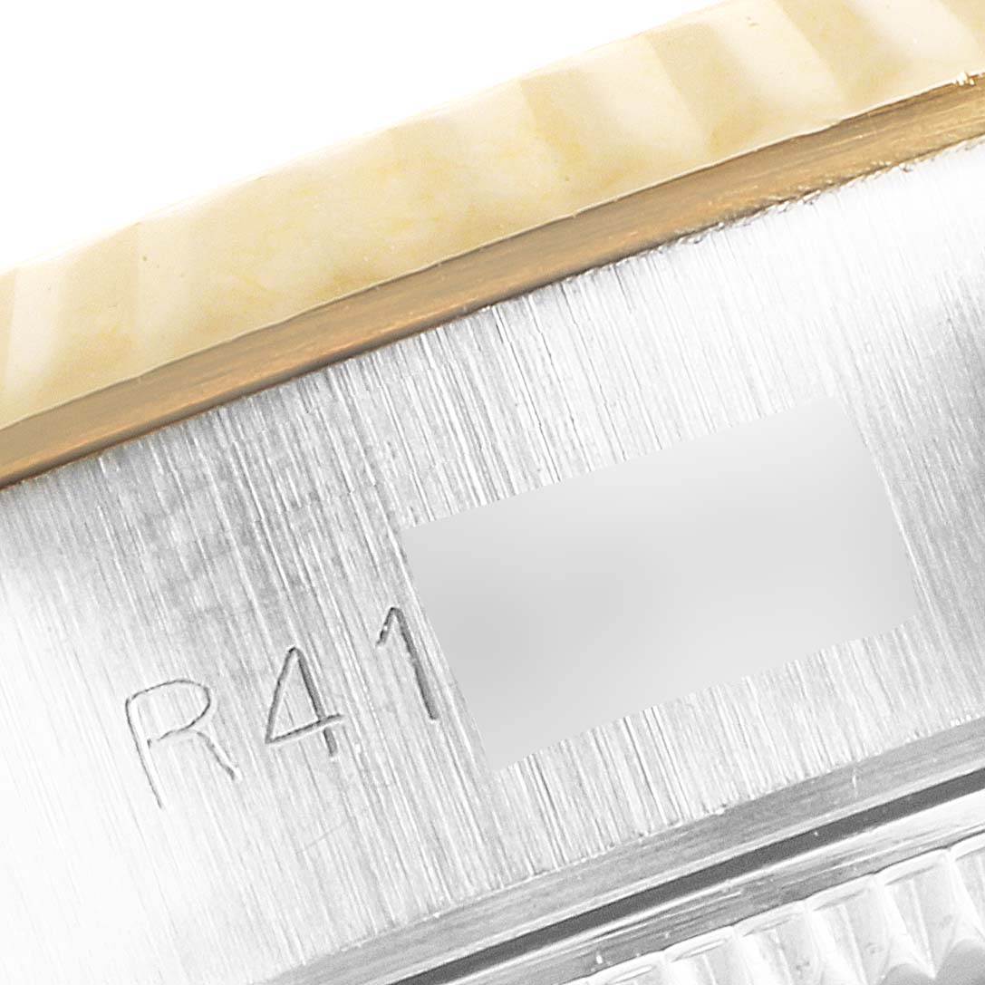 This close-up image of the Rolex Datejust 69173 Women's Steel and Gold (two tone) Champagne Dial 69173 Women's Steel and Gold (two tone) Champagne Dial shows part of the case and the edge of the bezel with some engraved text.
