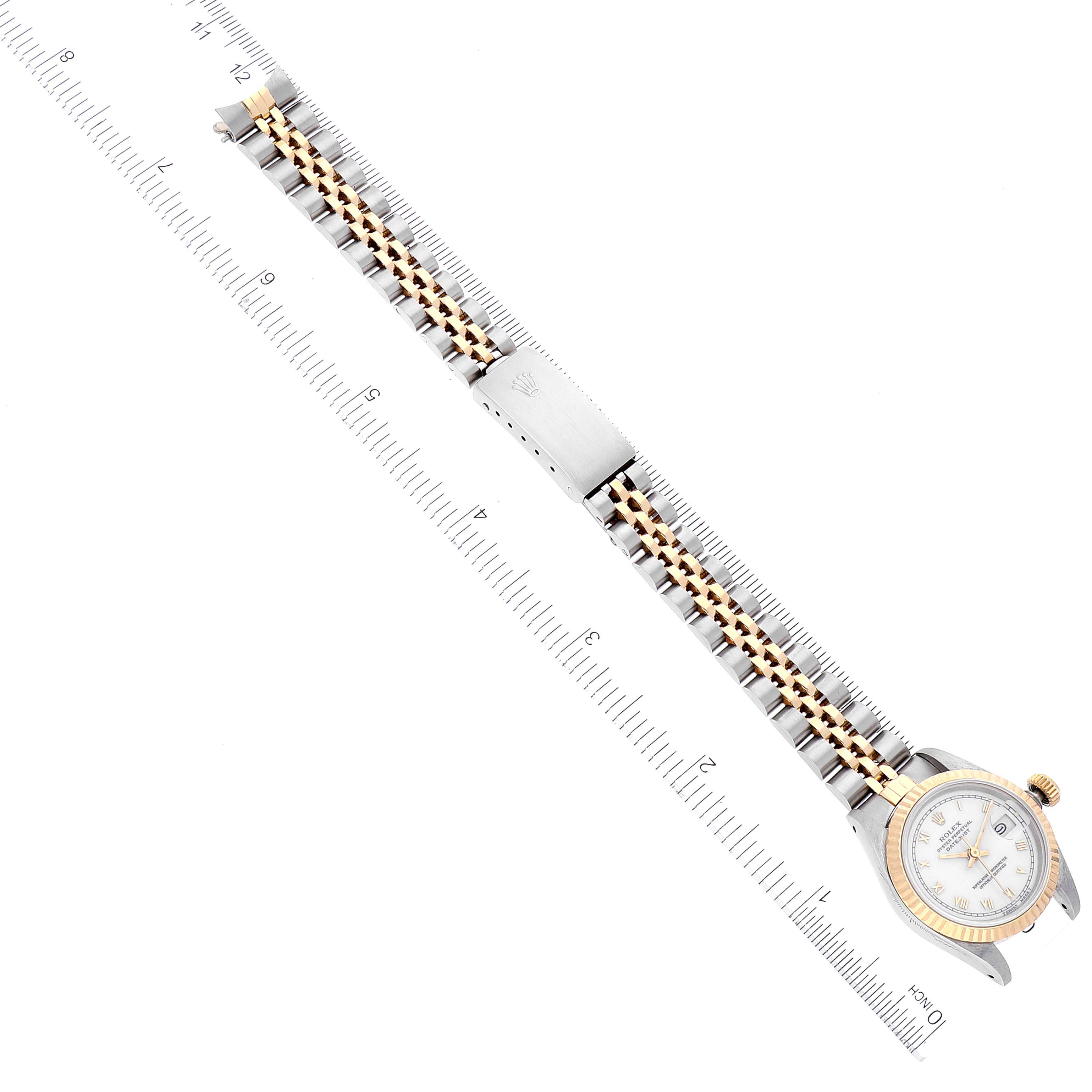 The image shows a top-down view of a Rolex Datejust 69173 Women's Steel and Gold (two tone) White Dial 69173 Women's Steel and Gold (two tone) White Dial watch with a two-tone bracelet next to a ruler.