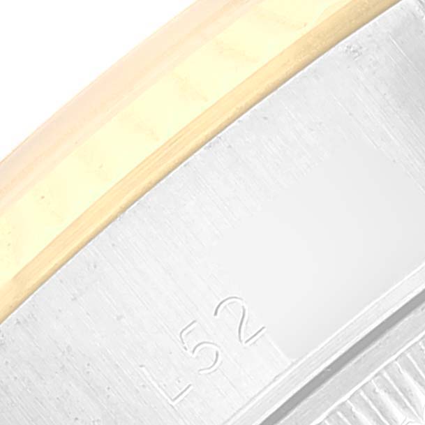 The image shows a close-up of the side of a Rolex Datejust 69173 Women's Steel and Gold (two tone) White Dial 69173 Women's Steel and Gold (two tone) White Dial watch, highlighting the bezel and the edge of the case with some engraved markings.