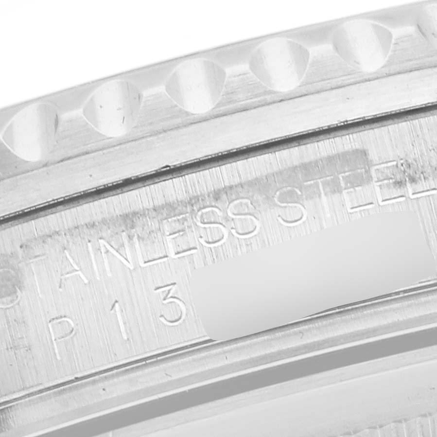 The image shows a close-up of the Rolex GMT-Master 16710 Men's Stainless Steel Black Dial 16710 Men's Stainless Steel Black Dial's stainless steel case with part of its engraved serial number.