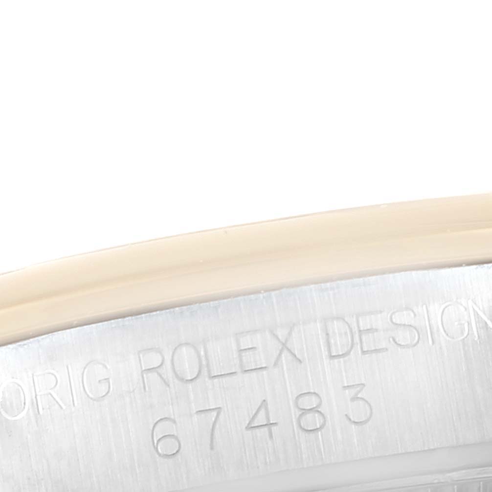 The image shows a close-up angle of the Mid-Size Rolex model, focusing on the engraved serial number and text on the case.