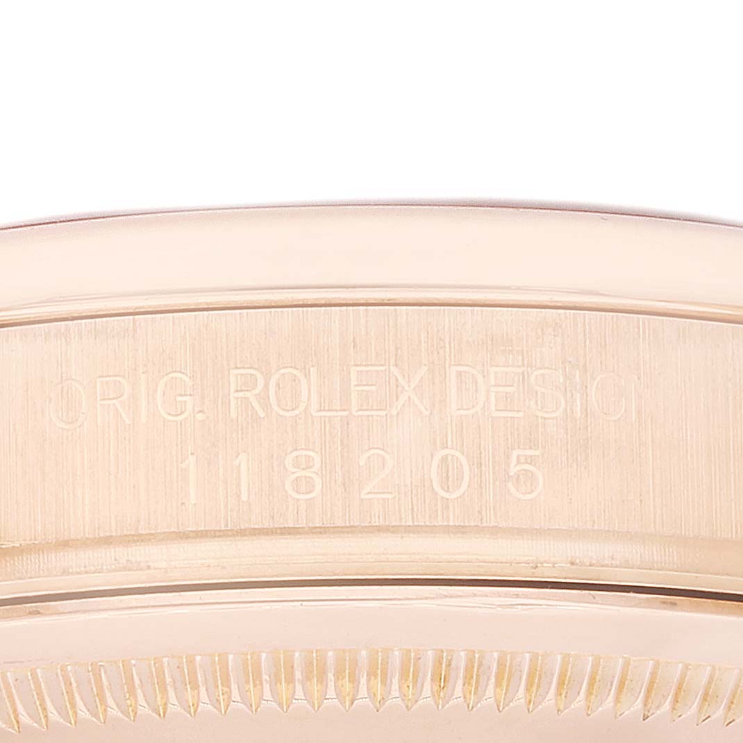 This image shows a close-up of the case's edge and serial number of a Rolex President 118205 Men's Rose Gold Silver Dial 118205 Men's Rose Gold Silver Dial model watch.