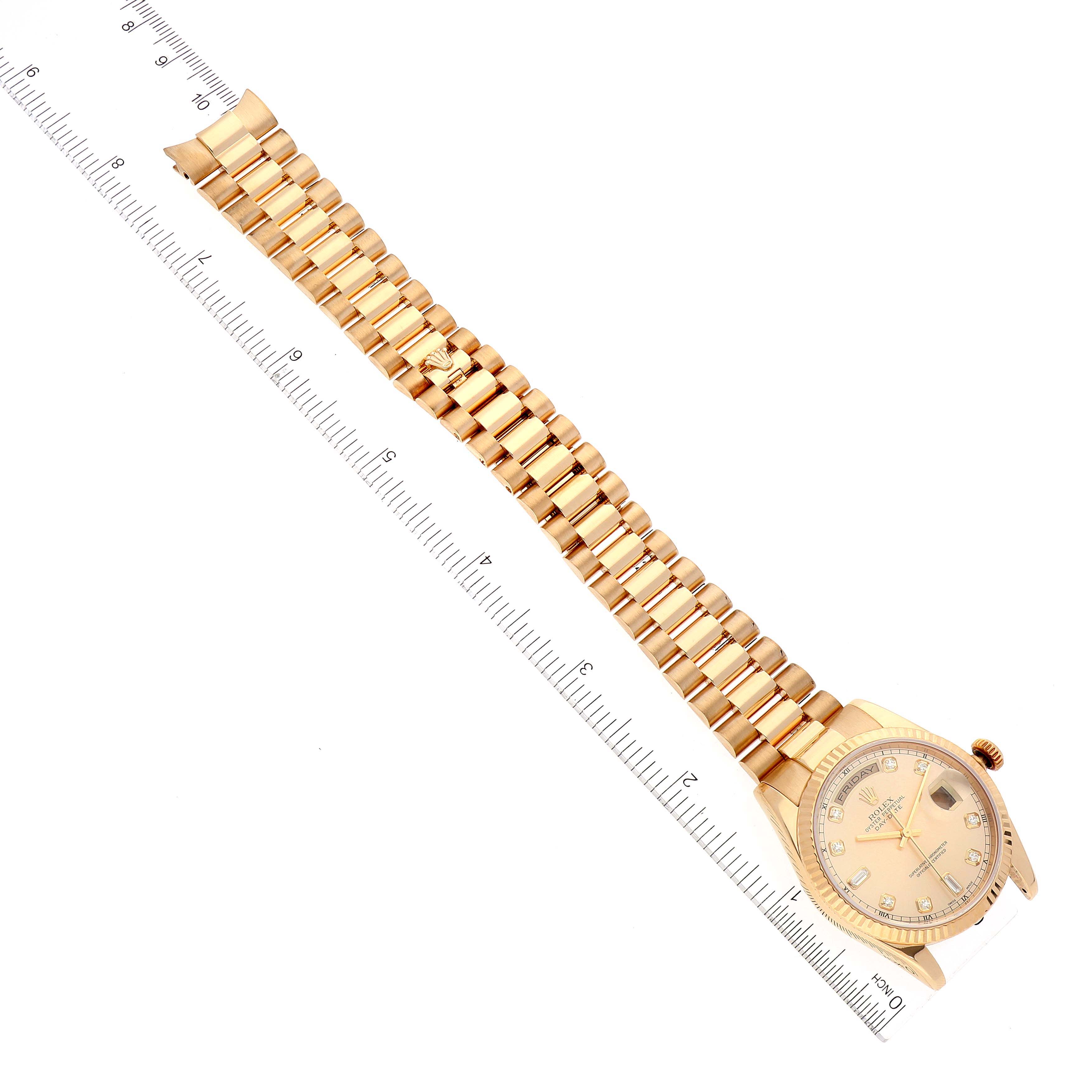 The image shows a Rolex President 118238 Men
s Yellow Gold Champagne Dial 118238 Men
s Yellow Gold Champagne Dial model watch laid flat, displaying its face, bracelet, and a ruler for scale.