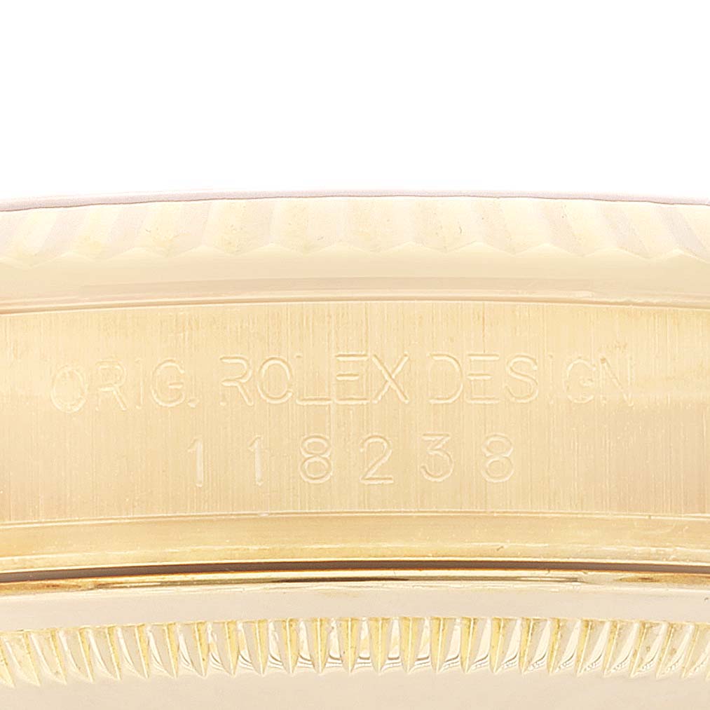 This image shows a close-up of the case and bezel of a Rolex President 118238 Men
s Yellow Gold Champagne Dial 118238 Men
s Yellow Gold Champagne Dial model, focusing on the engraving.