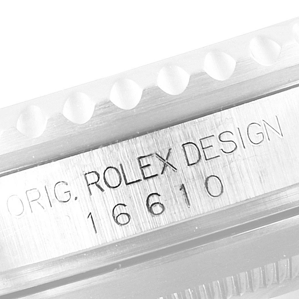 The image shows a close-up of the side engraving on a Rolex Submariner 16610 Men
s Stainless Steel Black Dial 16610 Men
s Stainless Steel Black Dial, displaying "ORIG. ROLEX DESIGN 16610."