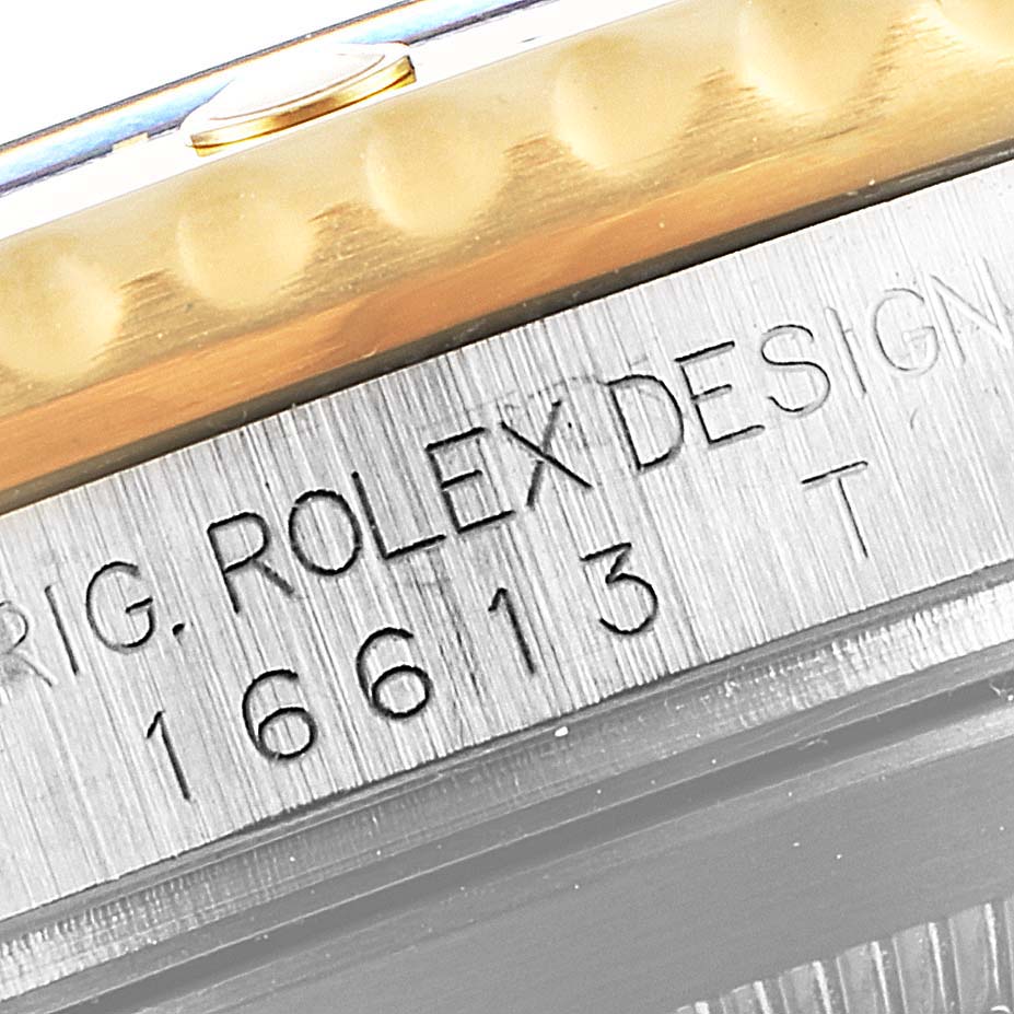 This close-up image shows the side engraving of a Rolex Submariner 16613 Men's Steel and Gold (two tone) Champagne Dial 16613 Men's Steel and Gold (two tone) Champagne Dial Model 16613, focusing on the bezel and part of the case.