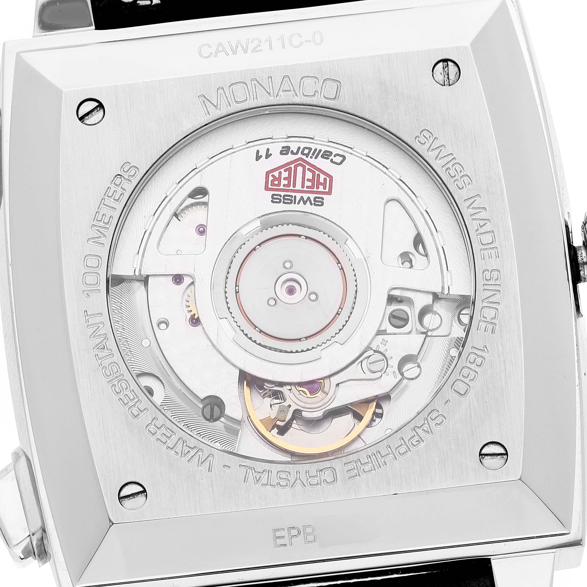 The image shows the back view of the Tag Heuer Monaco watch, highlighting its movement and internal mechanics.