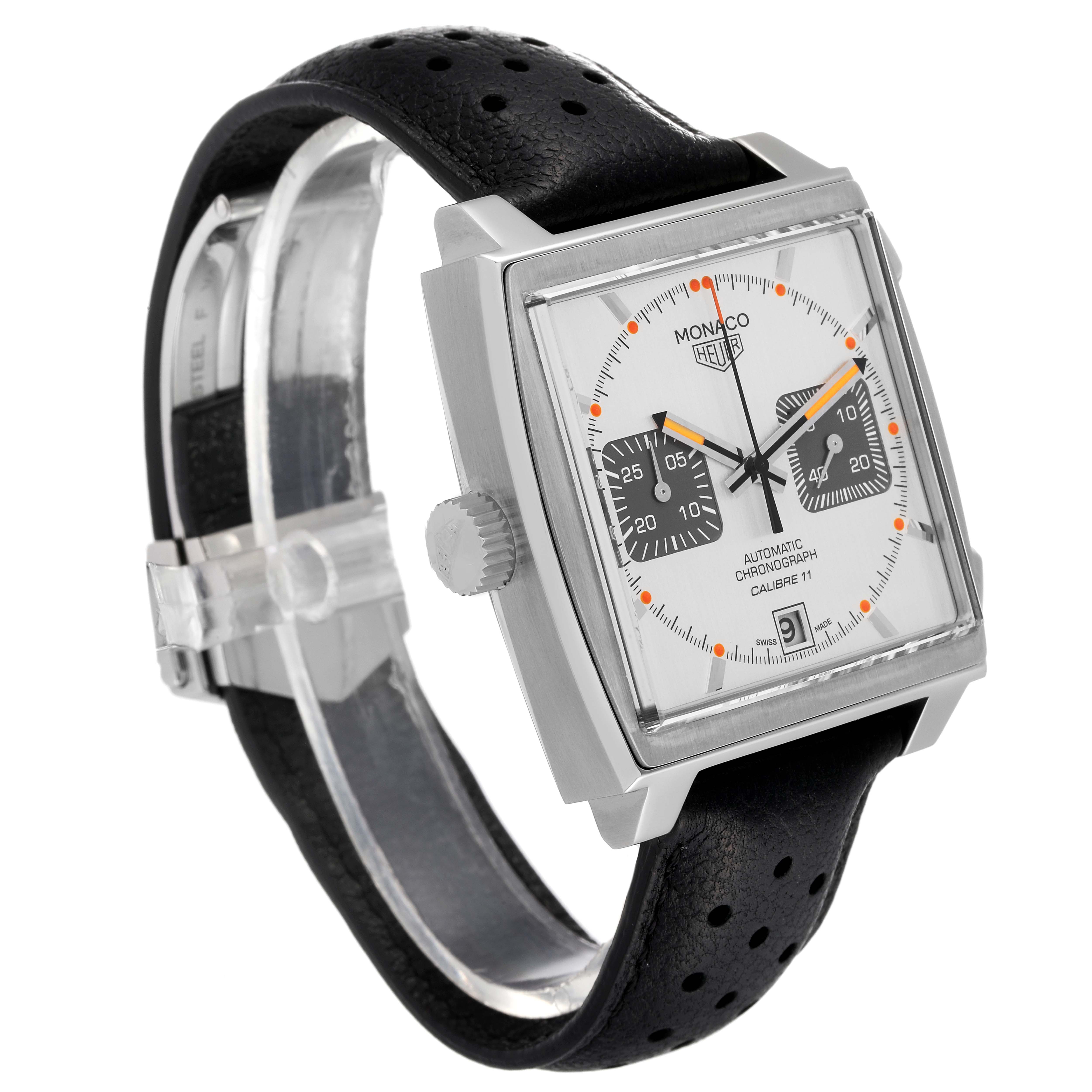 The image shows a Tag Heuer Monaco watch angled to display the face, crown, and part of the perforated black leather strap.