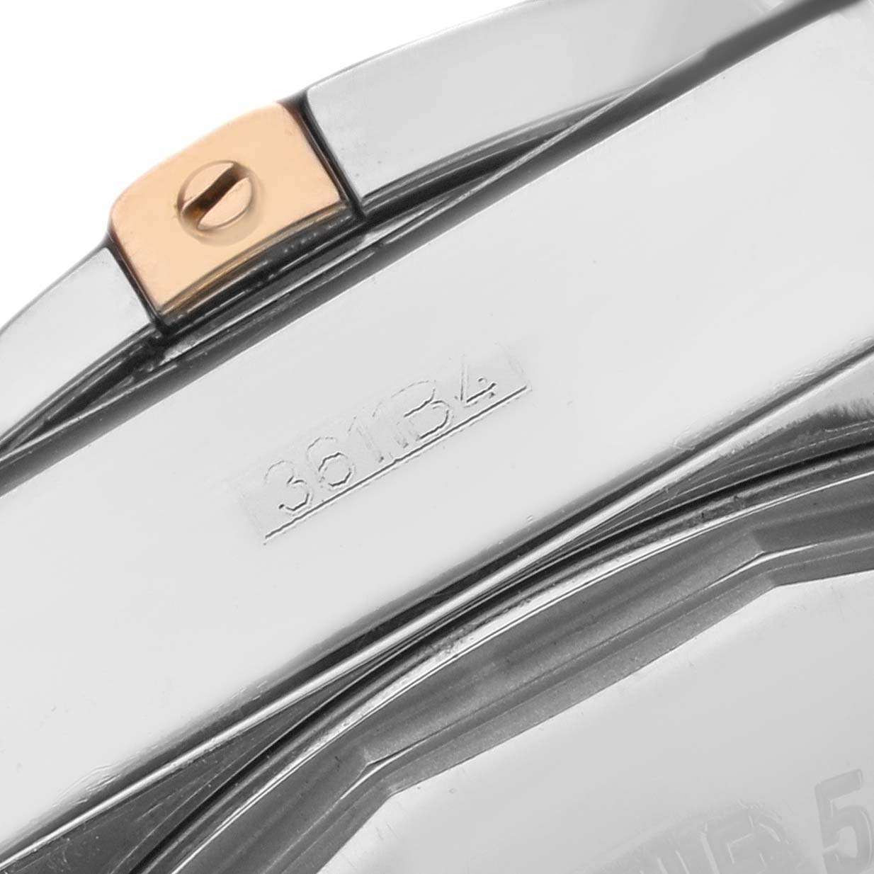 The image shows a close-up of the bezel and part of the case of a Breitling Chronomat IB0110 Men's Steel and Gold (two tone) Black Dial IB0110 Men's Steel and Gold (two tone) Black Dial watch, highlighting the serial number.