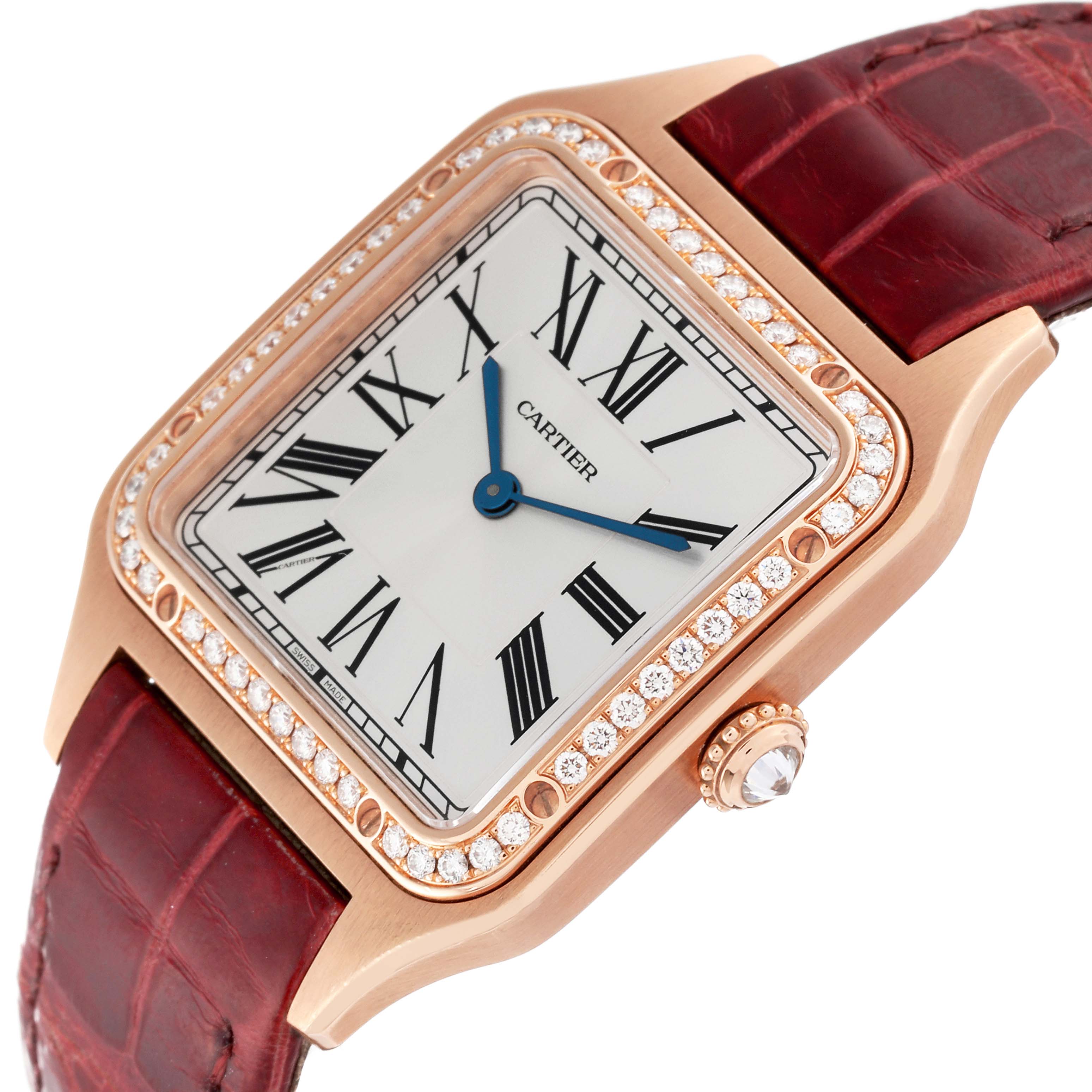 The image shows a Santos model by Cartier from an angled view, highlighting its dial, bejeweled bezel, and red strap.