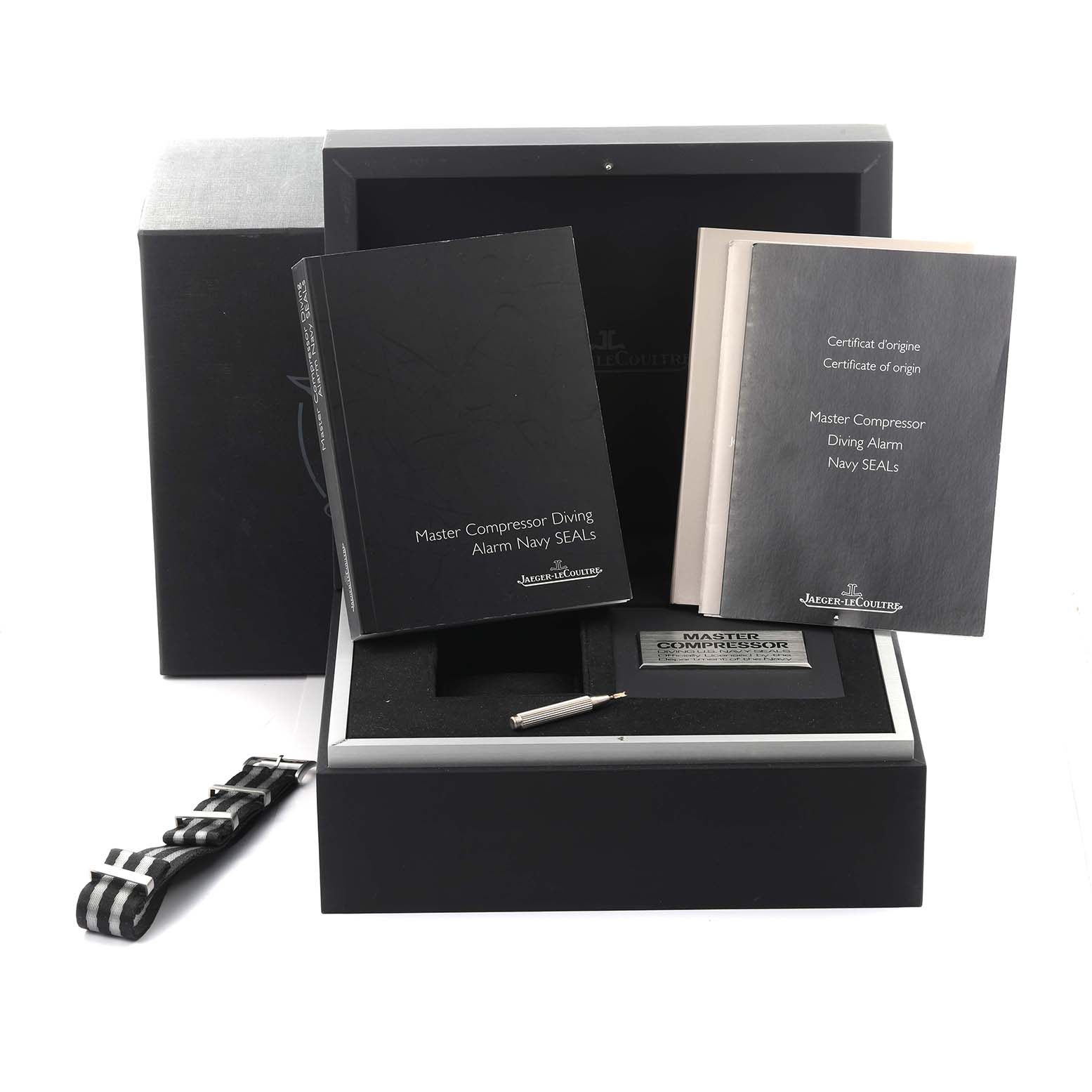 The image shows accessories for the Jaeger LeCoultre Master Q183T770 Men's Titanium Black Dial Q183T770 Men's Titanium Black Dial model, including manuals, a tool, and a strap, at an angle.