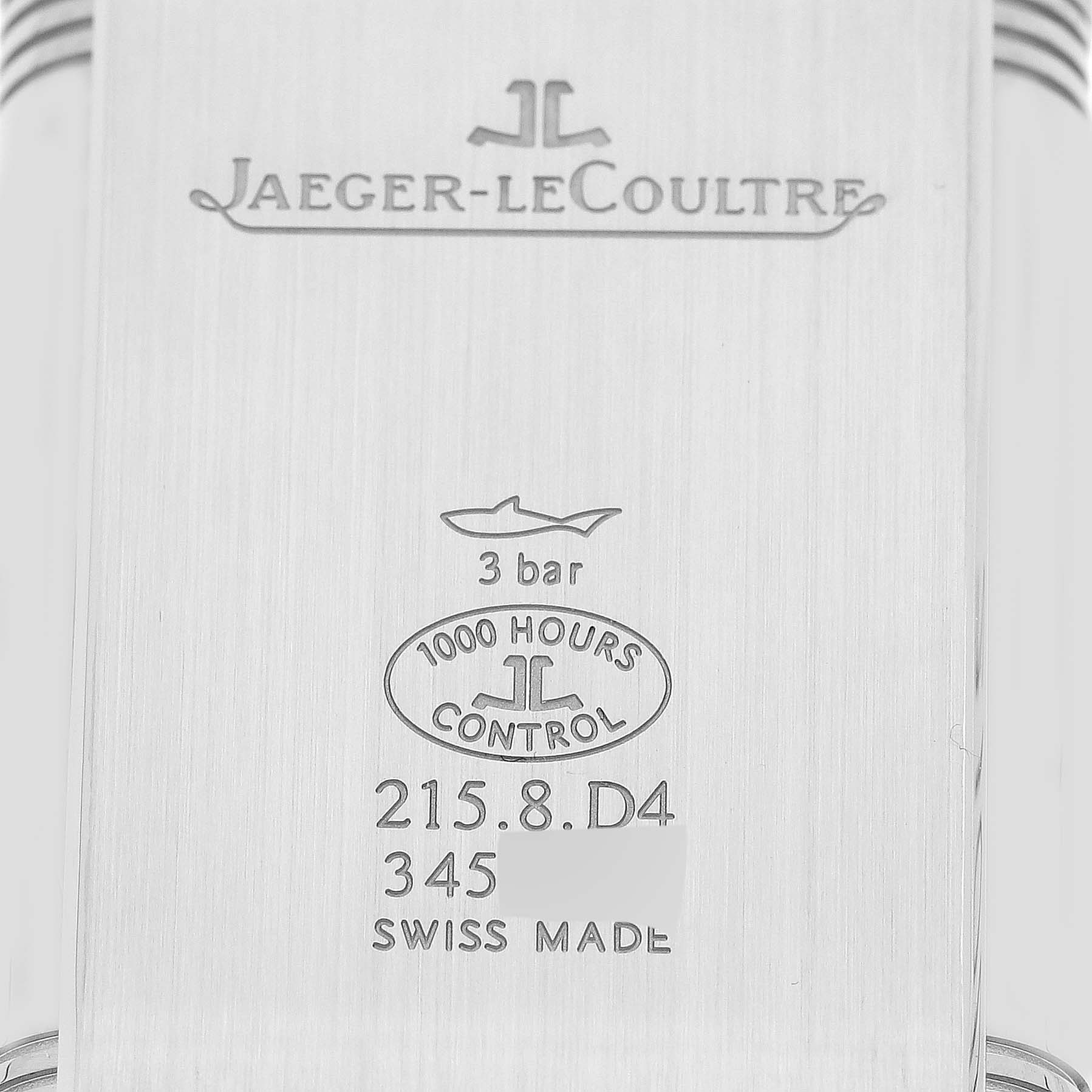This image shows the back casing of a Jaeger-LeCoultre Reverso watch, featuring engravings and brand markings.