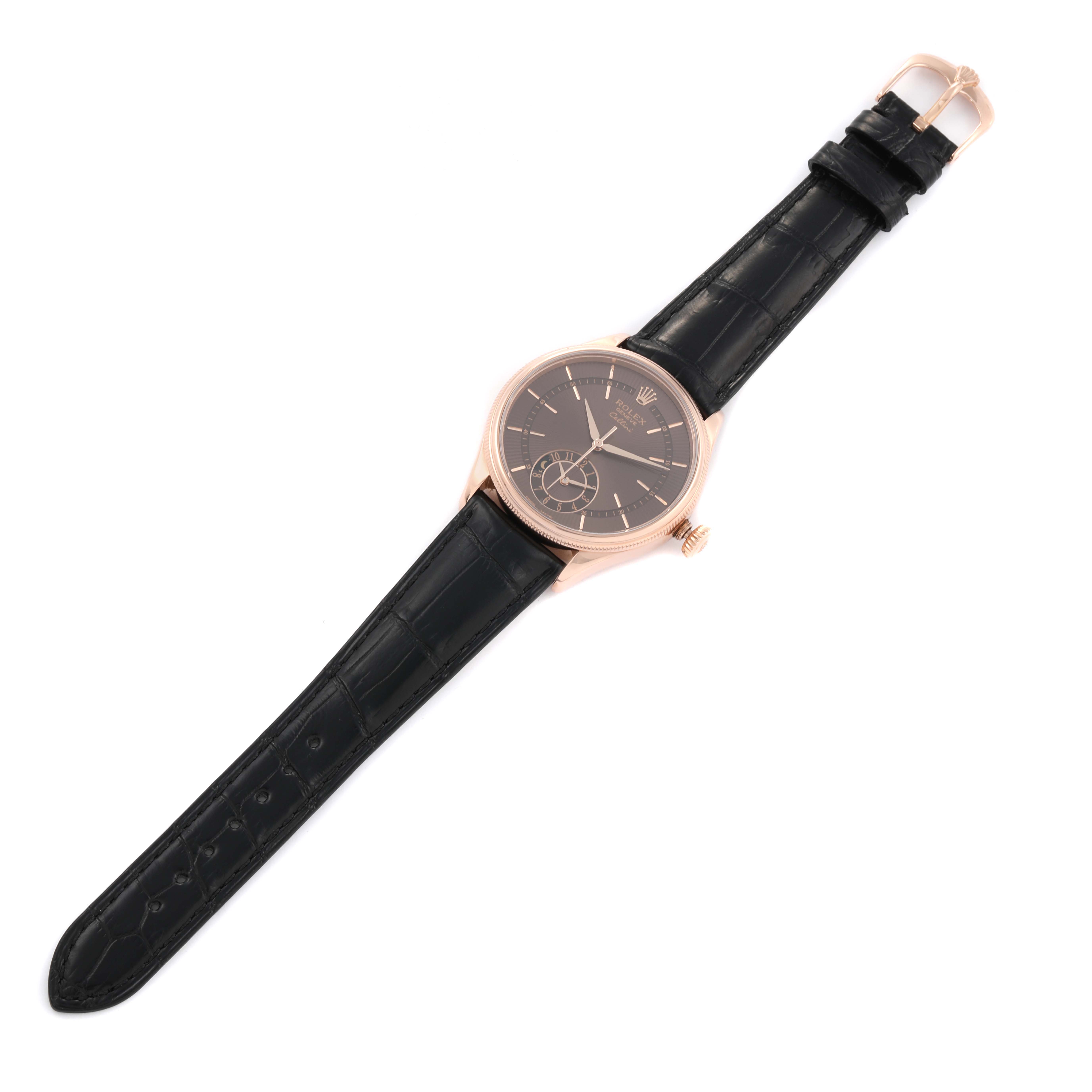 The Rolex Cellini 50525 Men's Rose Gold Brown Dial 50525 Men's Rose Gold Brown Dial watch is shown at an angled top-down view, displaying its black dial, rose gold case, and black leather strap.