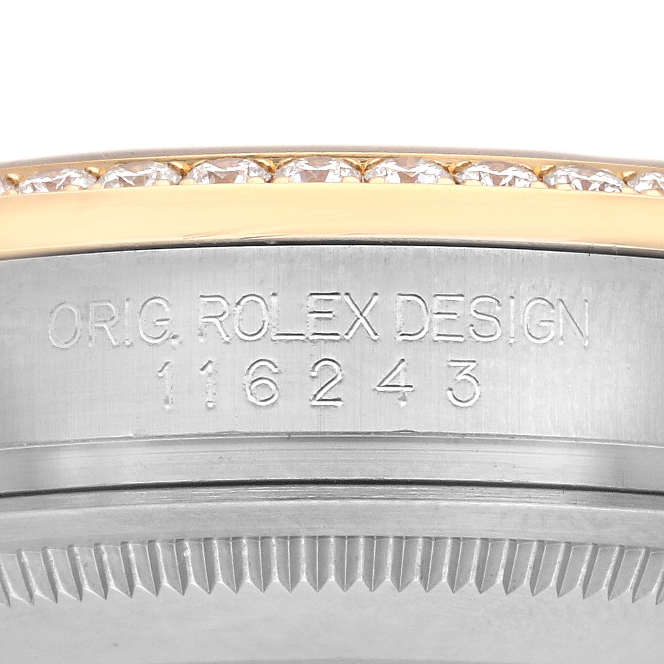 The image shows a close-up of the Rolex Datejust 116243 Men
s Steel and Gold (two tone) Silver Dial 116243 Men
s Steel and Gold (two tone) Silver Dial
s case side, featuring a diamond bezel and engraved design numbers.