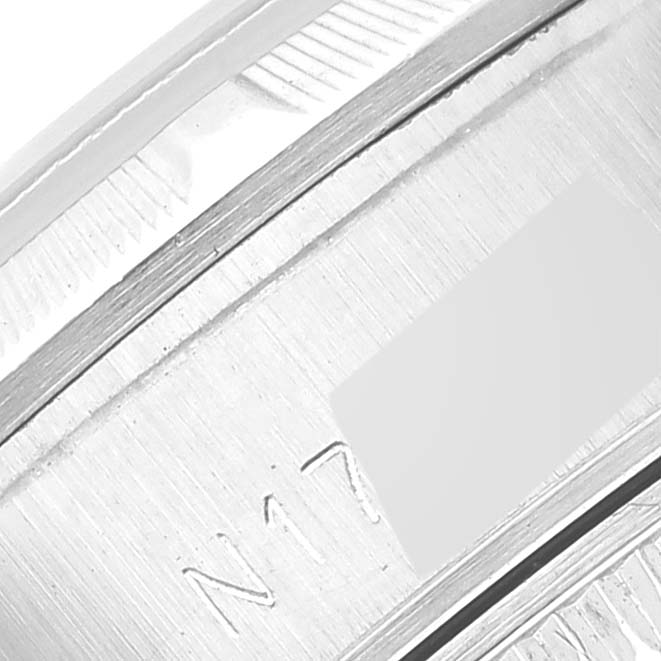 This image shows a close-up of the side of a Rolex Datejust 69190 Women's Stainless Steel Blue Dial 69190 Women's Stainless Steel Blue Dial watch, focusing on its engraved serial number and fluted bezel.