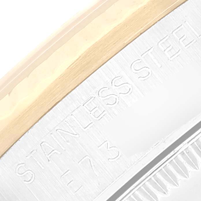 The image shows a close-up of the bezel and case of a Mid-Size Rolex watch with "STAINLESS STEEL" engraved.