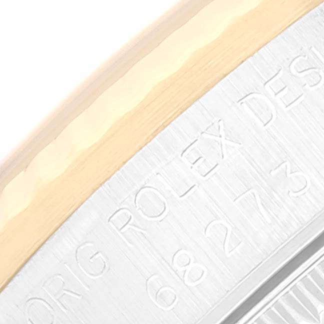 The image shows a close-up of the case edge and bezel of a Rolex Mid-Size 68273 Women
s Steel and Gold (two tone) Champagne Dial 68273 Women
s Steel and Gold (two tone) Champagne Dial model watch with engravings.