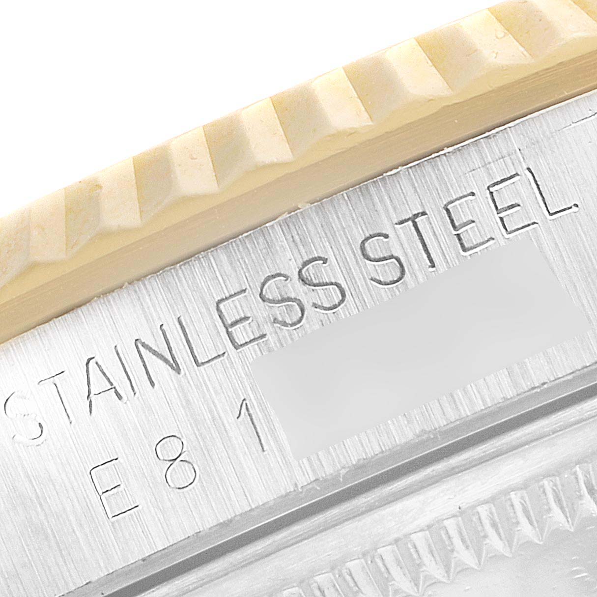 This close-up image shows part of the bezel and case of the Rolex Datejust 16233 Men's Steel and Gold (two tone) Champagne Dial 16233 Men's Steel and Gold (two tone) Champagne Dial watch, with "STAINLESS STEEL" engraved.