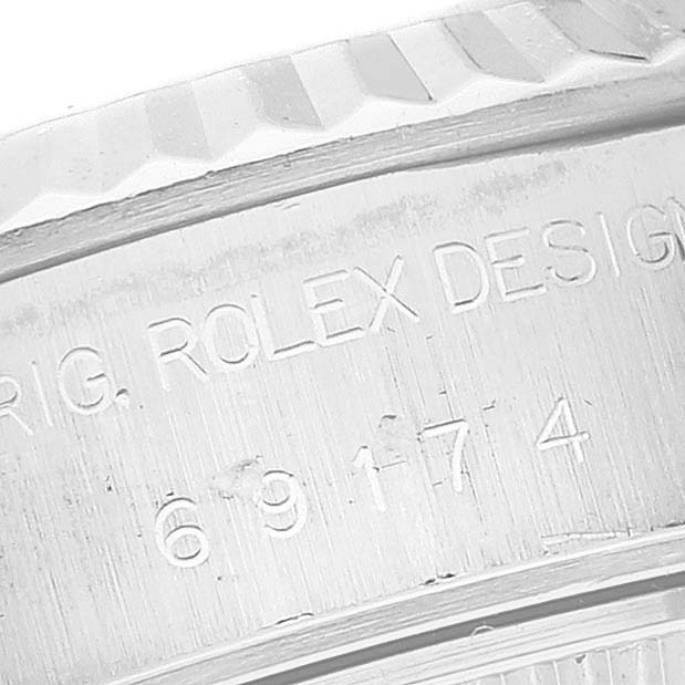 This image shows a close-up of the engraved serial number and "ROLEX DESIGN" on the side of a Rolex Datejust 69174 Women's Stainless Steel White Dial 69174 Women's Stainless Steel White Dial watch case.