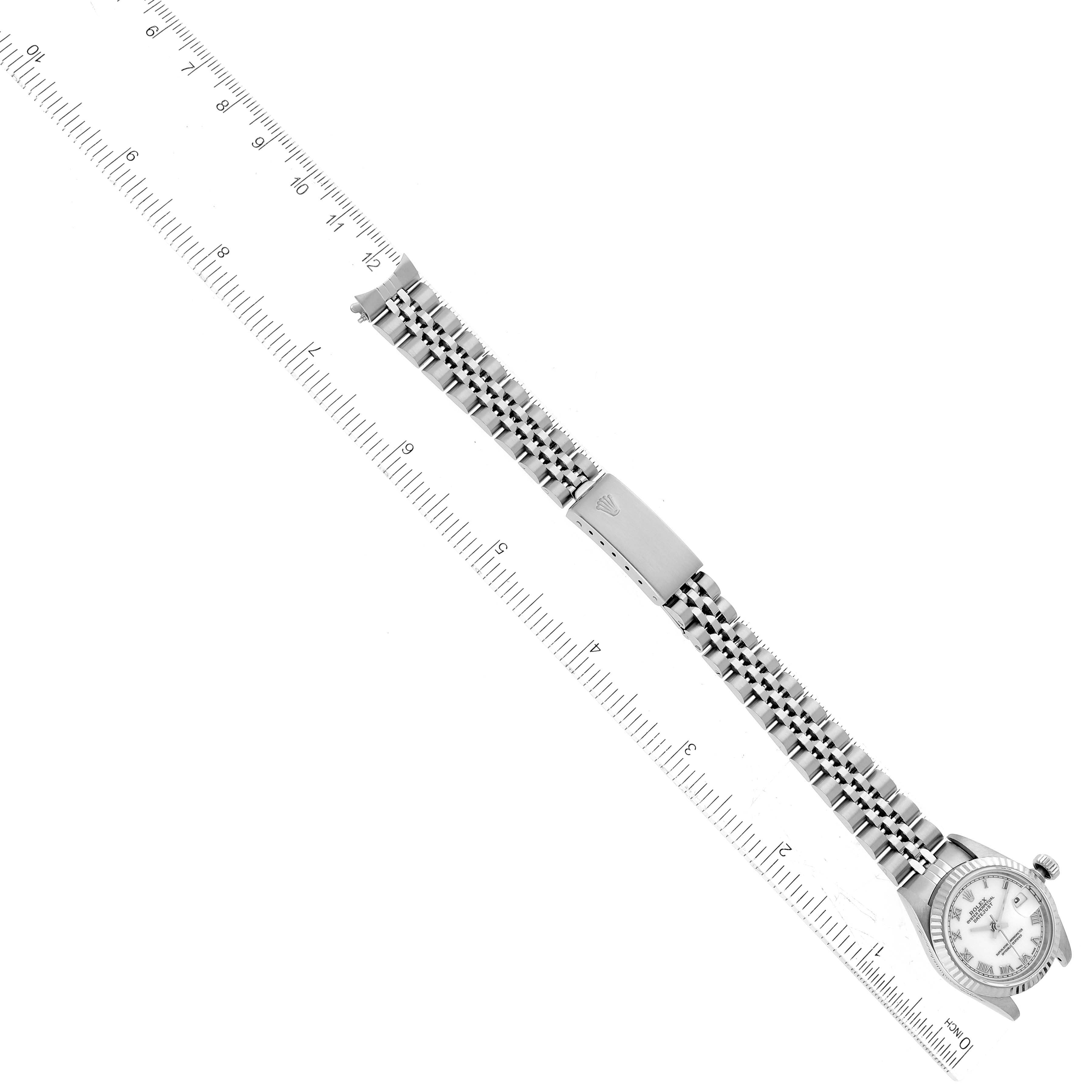 This image shows a top view of a Rolex Datejust 69174 Women's Stainless Steel White Dial 69174 Women's Stainless Steel White Dial watch laid out flat with a ruler parallel to its bracelet.