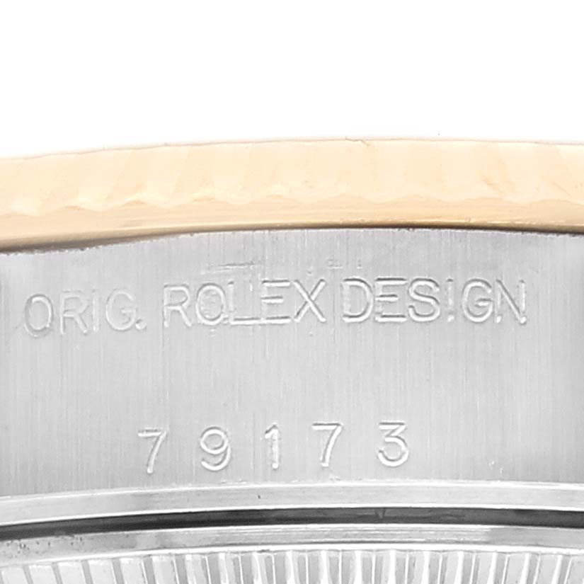 This image shows a close-up of the case side of a Rolex Datejust 79173 Women's Steel and Gold (two tone) Champagne Dial 79173 Women's Steel and Gold (two tone) Champagne Dial watch, featuring the engraving "ORIG. ROLEX DESIGN" and the model number "79173".