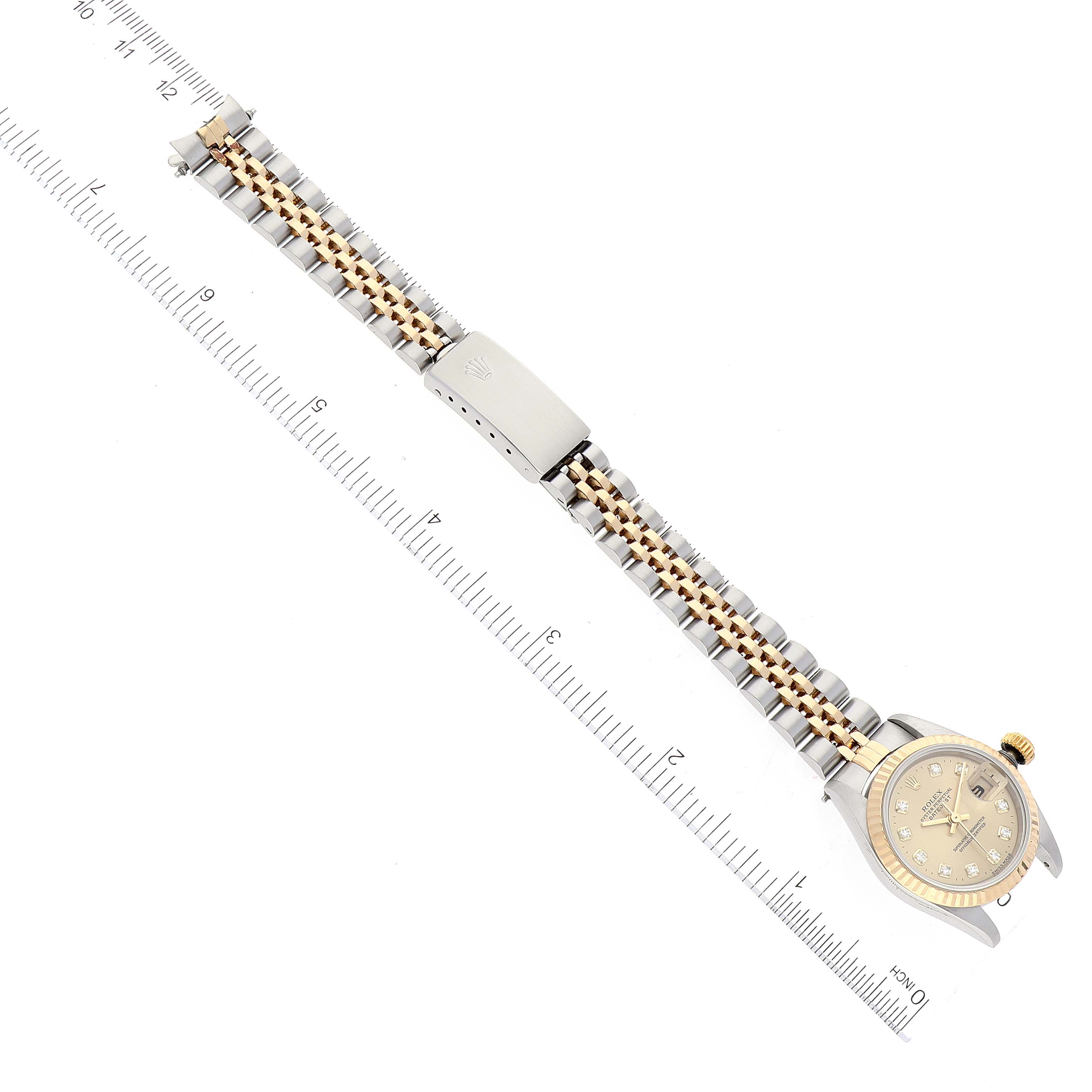 The Rolex Datejust 69173 Women's Steel and Gold (two tone) Champagne Dial 69173 Women's Steel and Gold (two tone) Champagne Dial watch is shown from an overhead angle, displaying the full bracelet, clasp, and watch face along a ruler.