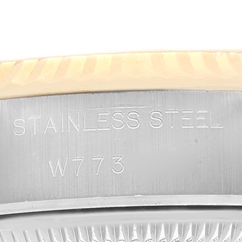 The image shows a close-up of the Rolex Datejust 69173 Women's Steel and Gold (two tone) Champagne Dial 69173 Women's Steel and Gold (two tone) Champagne Dial model's stainless steel case with partial view of its gold bezel and engraving.