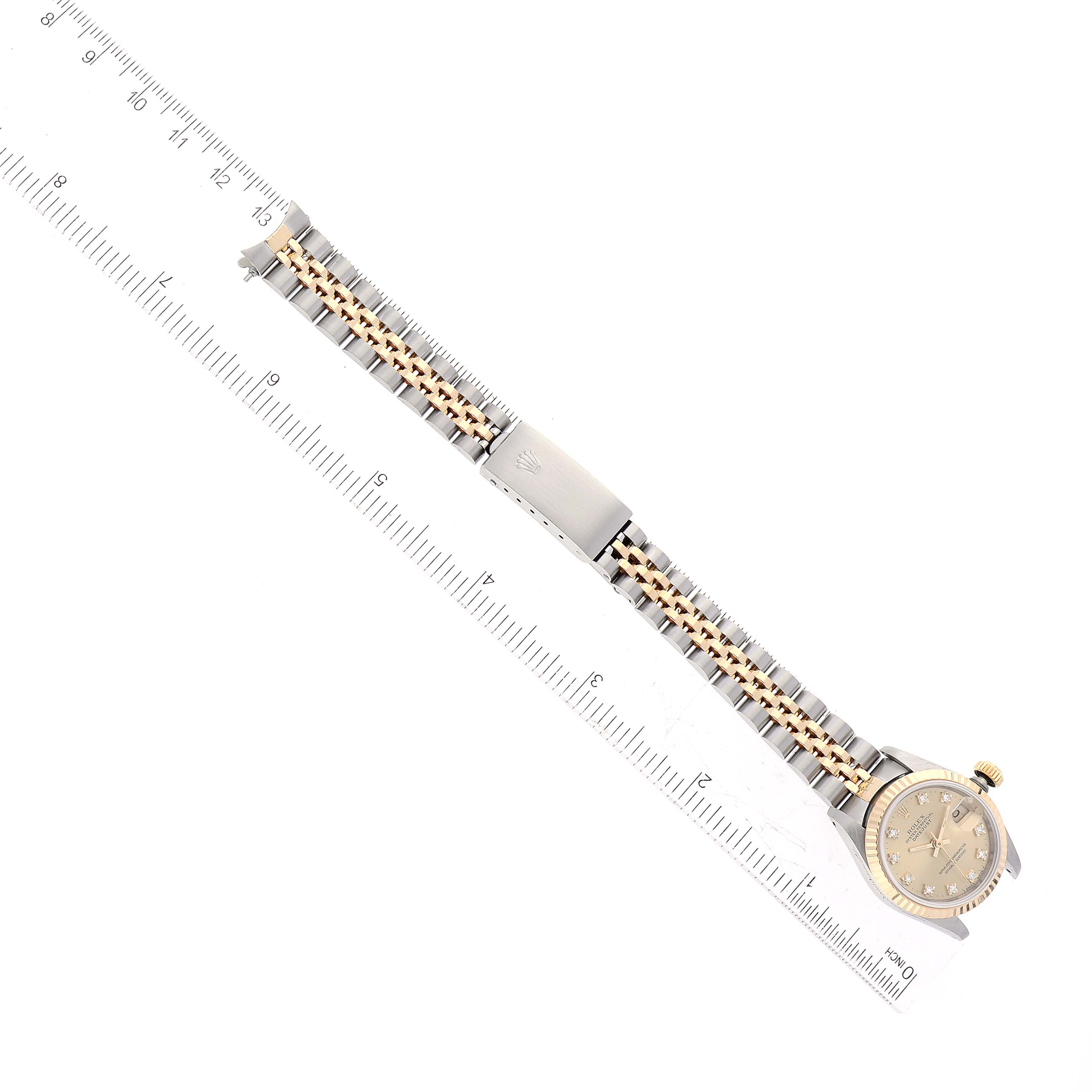 The image shows a top-down view of the Rolex Datejust 69173 Women's Steel and Gold (two tone) Champagne Dial 69173 Women's Steel and Gold (two tone) Champagne Dial watch, displaying the full bracelet and face alongside a ruler for size reference.