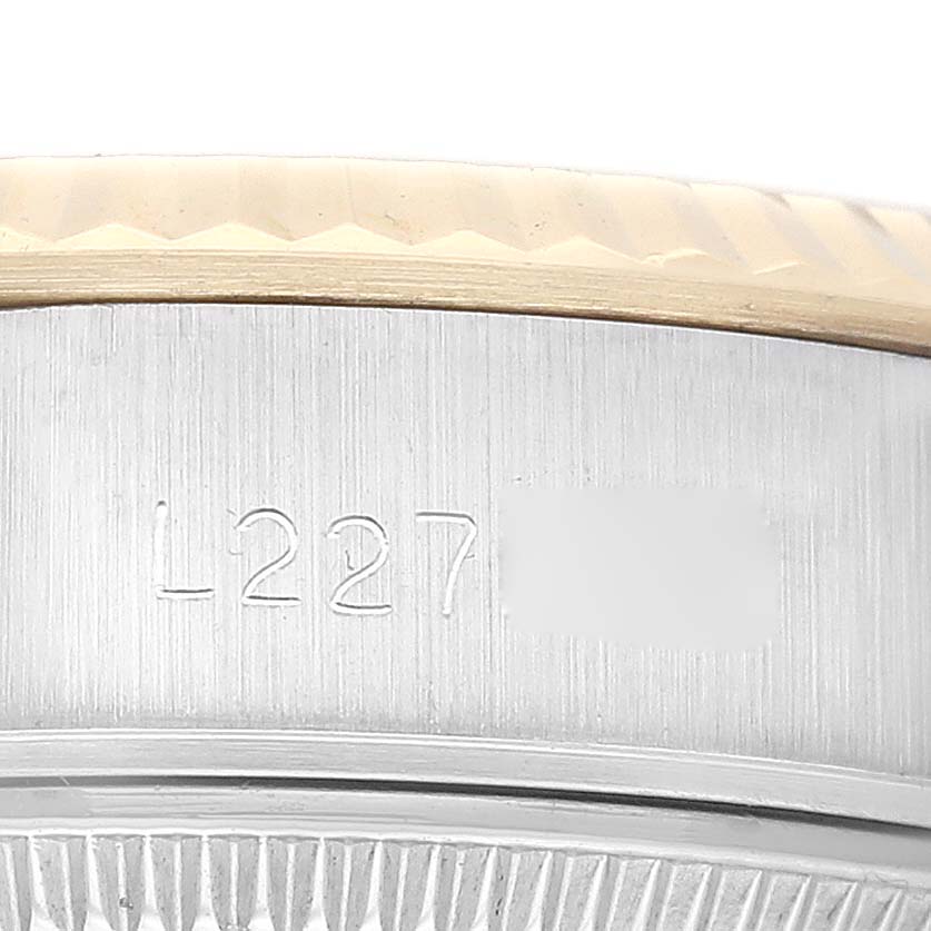 This image shows a close-up of the side case and bezel of a Rolex Datejust 69173 Women's Steel and Gold (two tone) Champagne Dial 69173 Women's Steel and Gold (two tone) Champagne Dial watch, with a serial number engraved on the case.