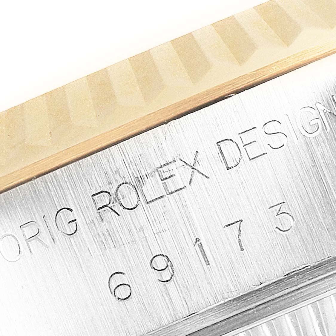 The image shows a close-up of the case and bezel of a Rolex Datejust 69173 Women's Steel and Gold (two tone) White Dial 69173 Women's Steel and Gold (two tone) White Dial watch with the model number engraved.