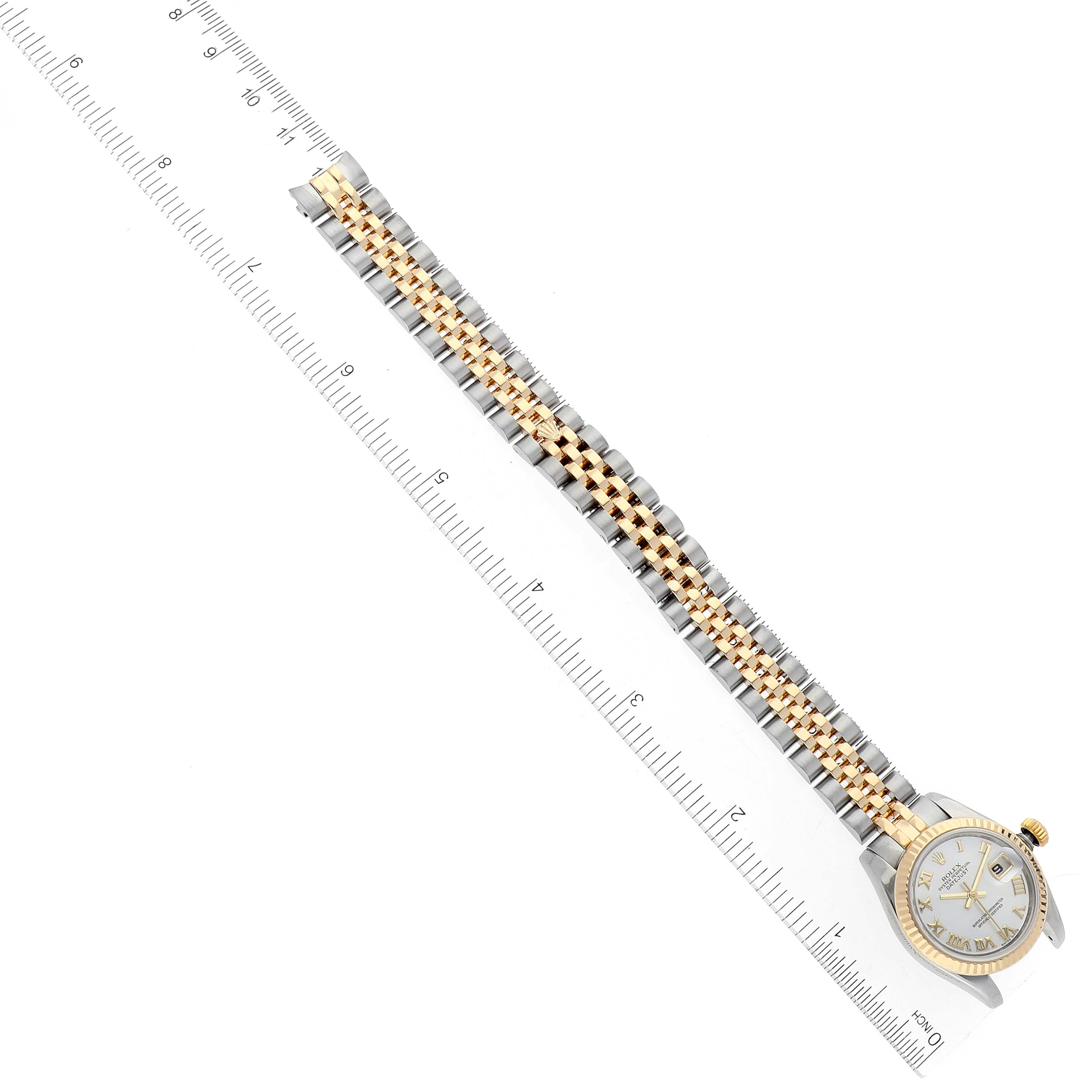 The Rolex Datejust 179173 Women's Steel and Gold (two tone) Mother of Pearl Dial 179173 Women's Steel and Gold (two tone) Mother of Pearl Dial watch is shown at a diagonal angle with the full bracelet and part of the watch face visible next to a ruler.