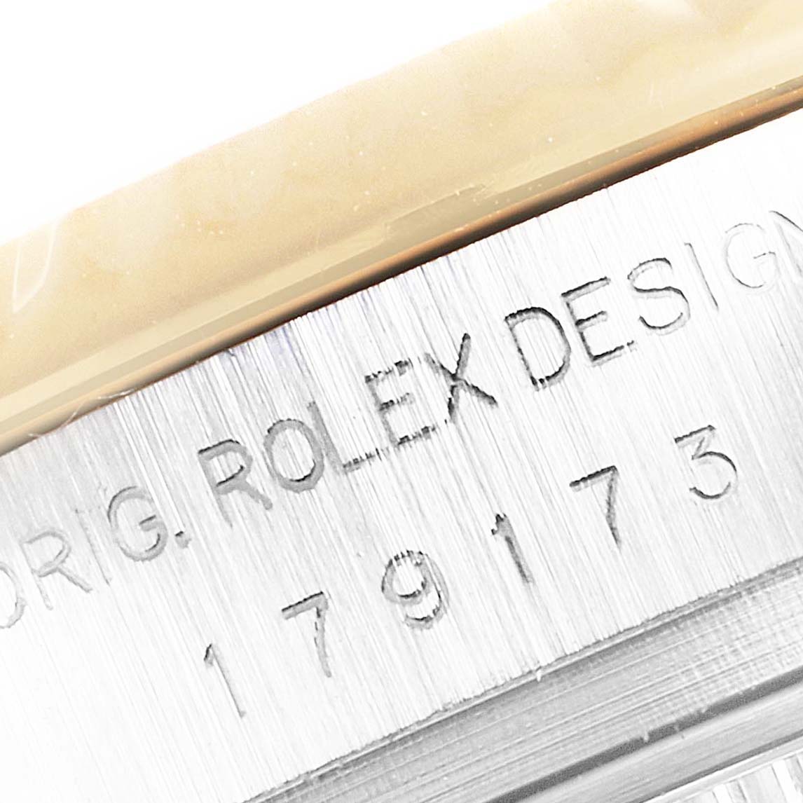 The image shows a close-up of the Rolex Datejust 179173 Women
s Steel and Gold (two tone) Mother of Pearl Dial 179173 Women
s Steel and Gold (two tone) Mother of Pearl Dial
s case edge, highlighting the engraved model number and "Rolex Design" text.